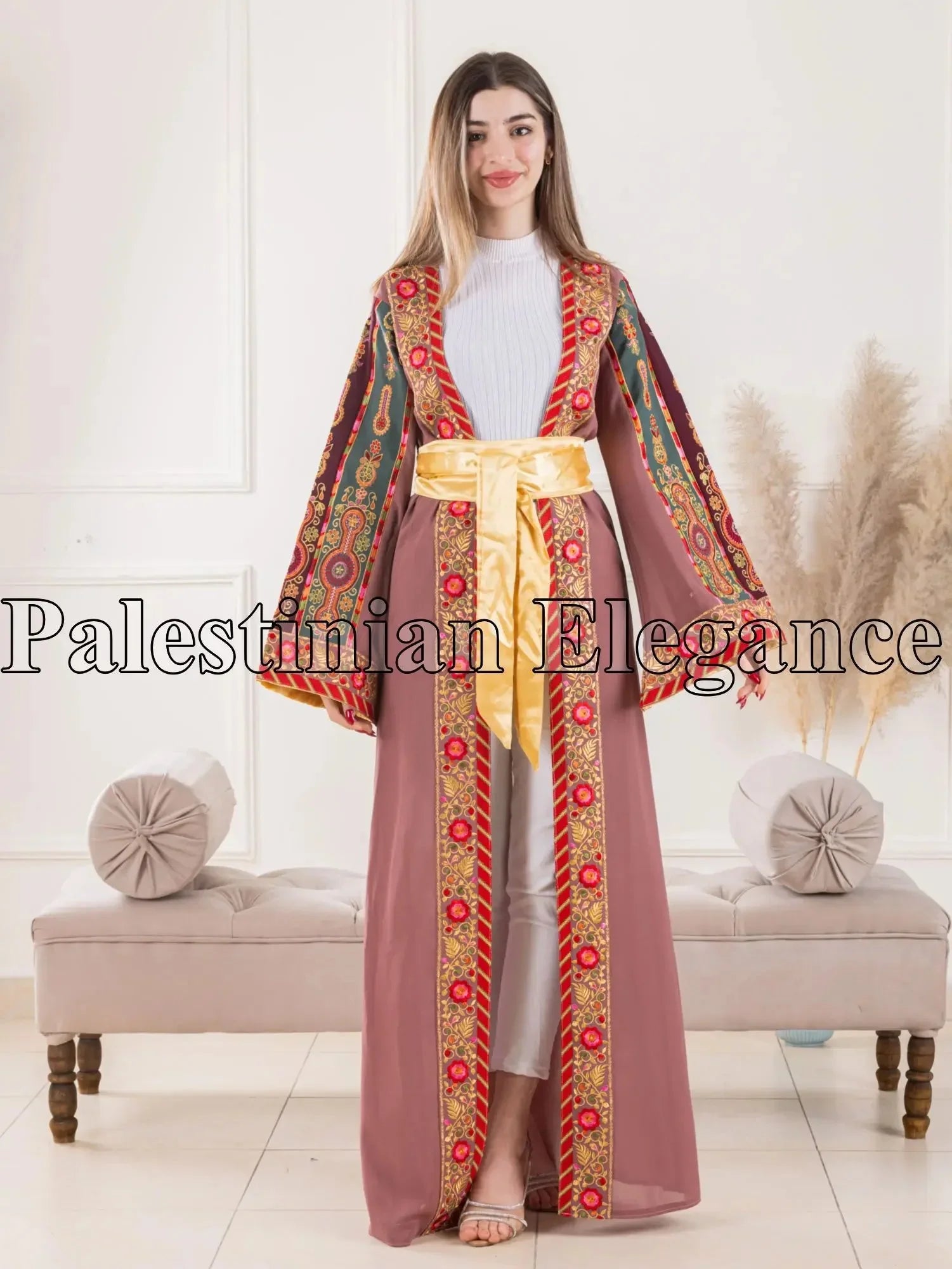 Aseel Malaka embroidered Cardigan by Palestinian Elegance worn by a woman with colorful intricate patterns and a yellow satin belt