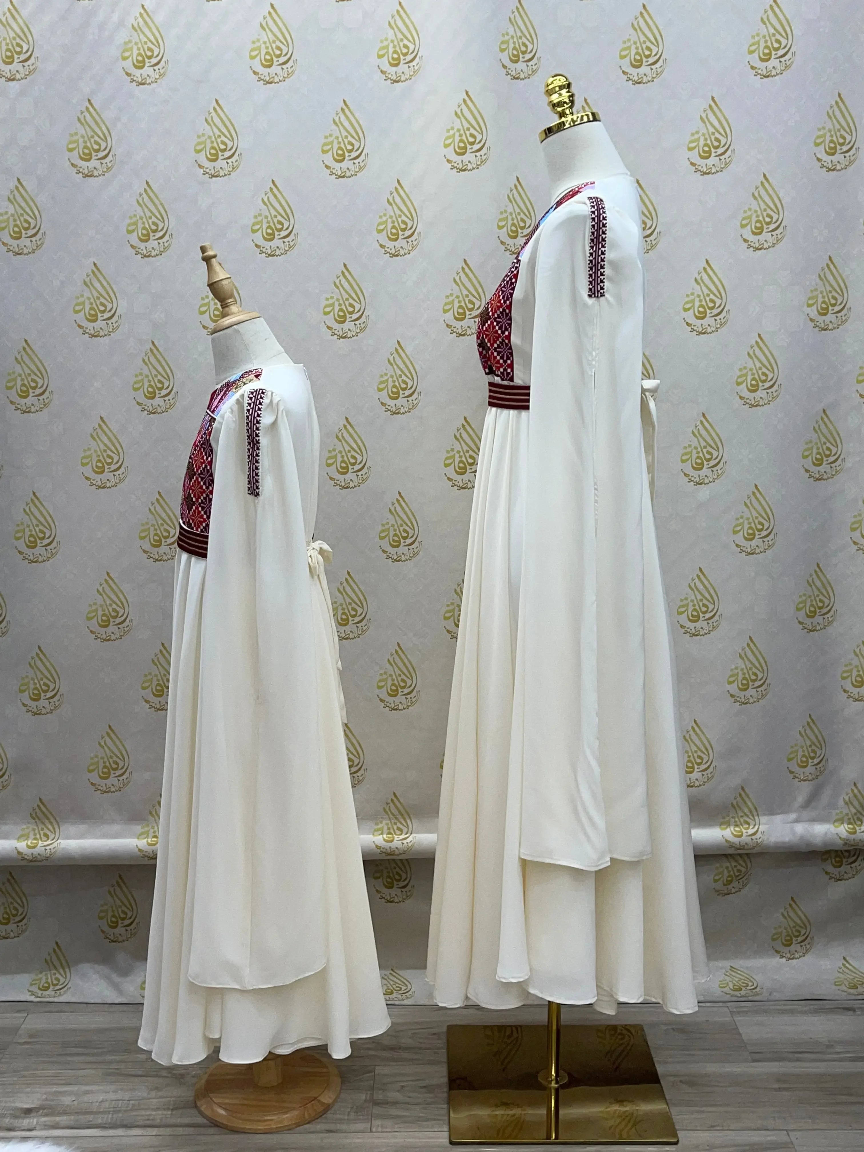 Palestinian girls embroidered dress in white with traditional red and black embroidery on mannequins