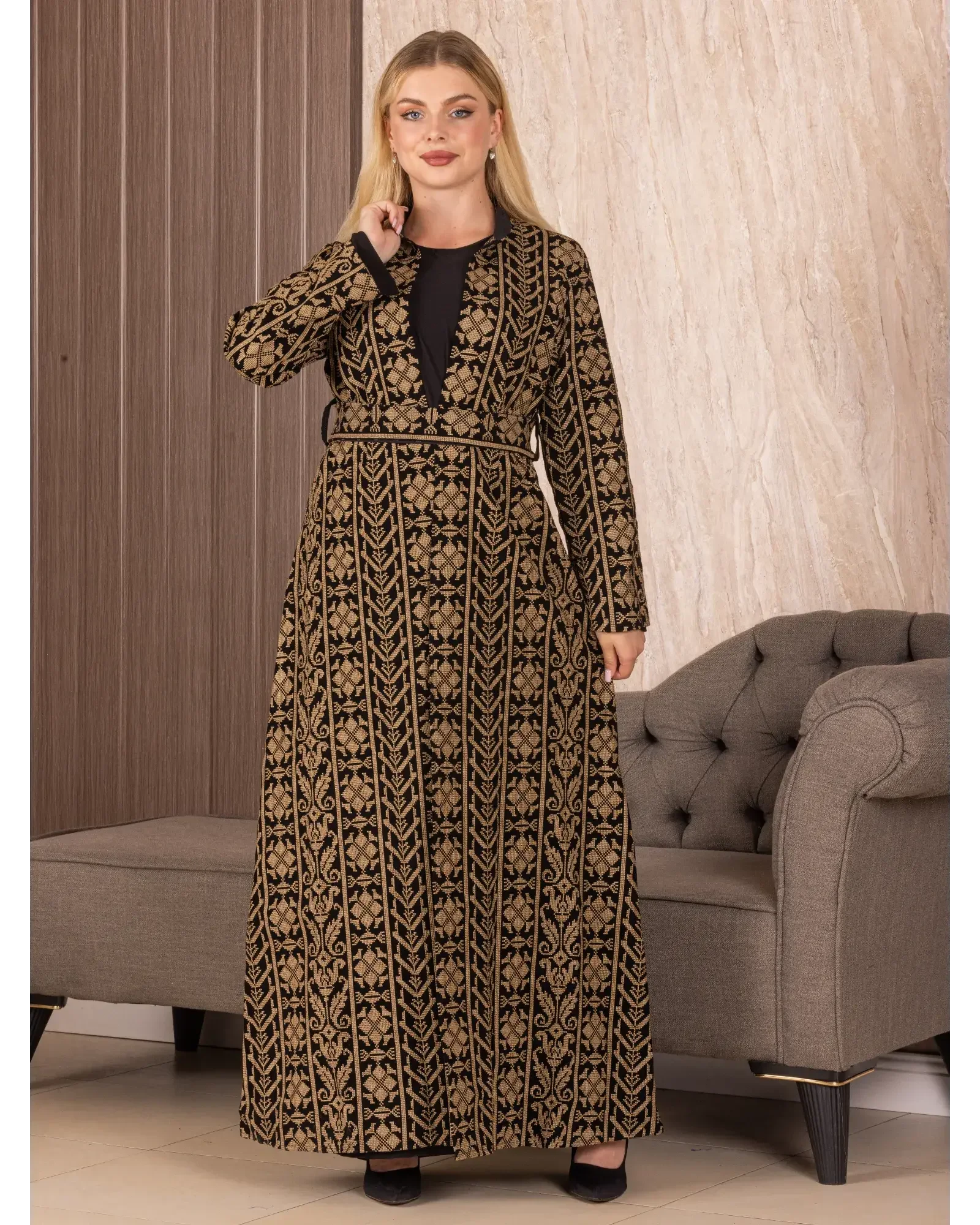 Palestinian Elegance embroidered long cardigan with black and gold floral patterns worn by woman indoors
