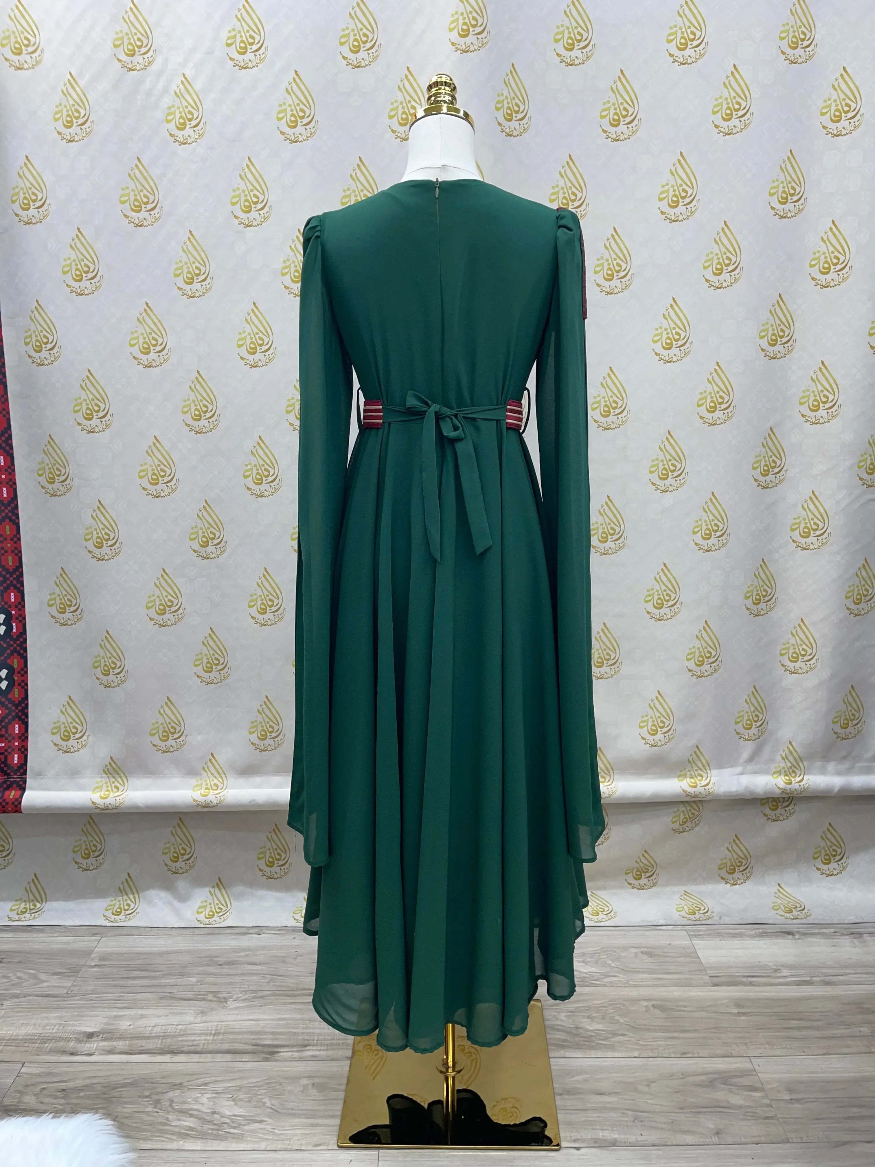 Back view of green Palestinian girls embroidered dress with long sleeves and waist tie by Palestinian Elegance