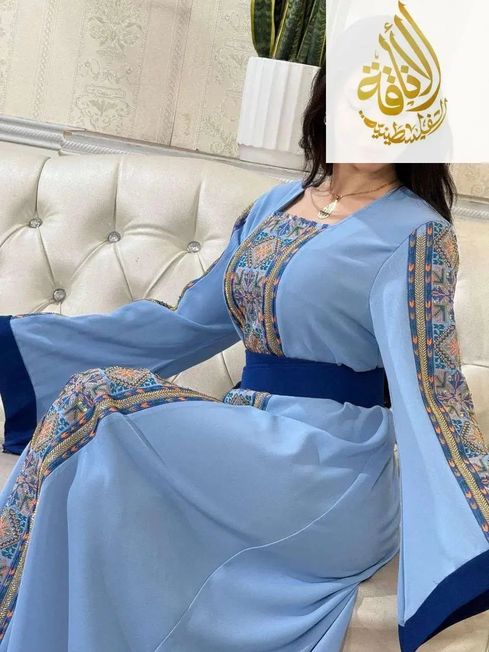 Woman wearing a Baby Blue Unique Embroidered Thoub with intricate patterned sleeves and chest details