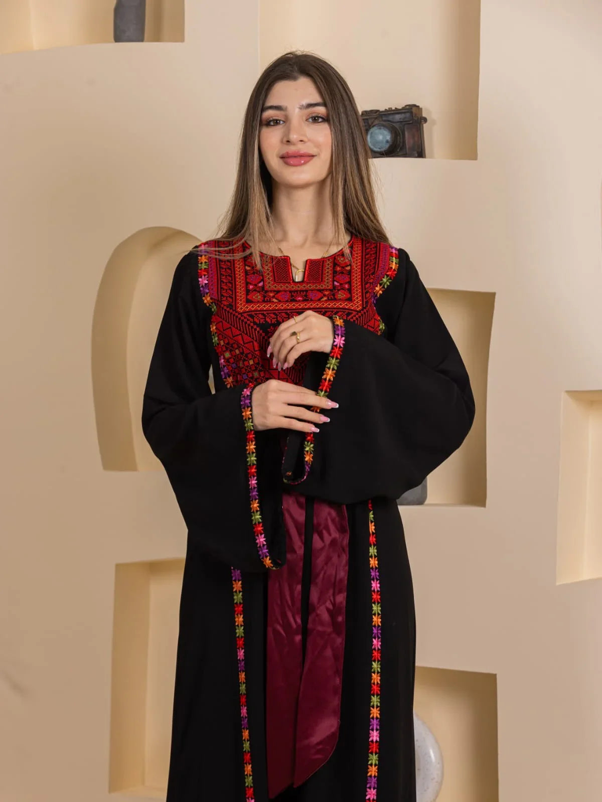 Blossom Embroidered Thobe by Palestinian Elegance black thobe with red embroidered yoke colorful trim and maroon sash