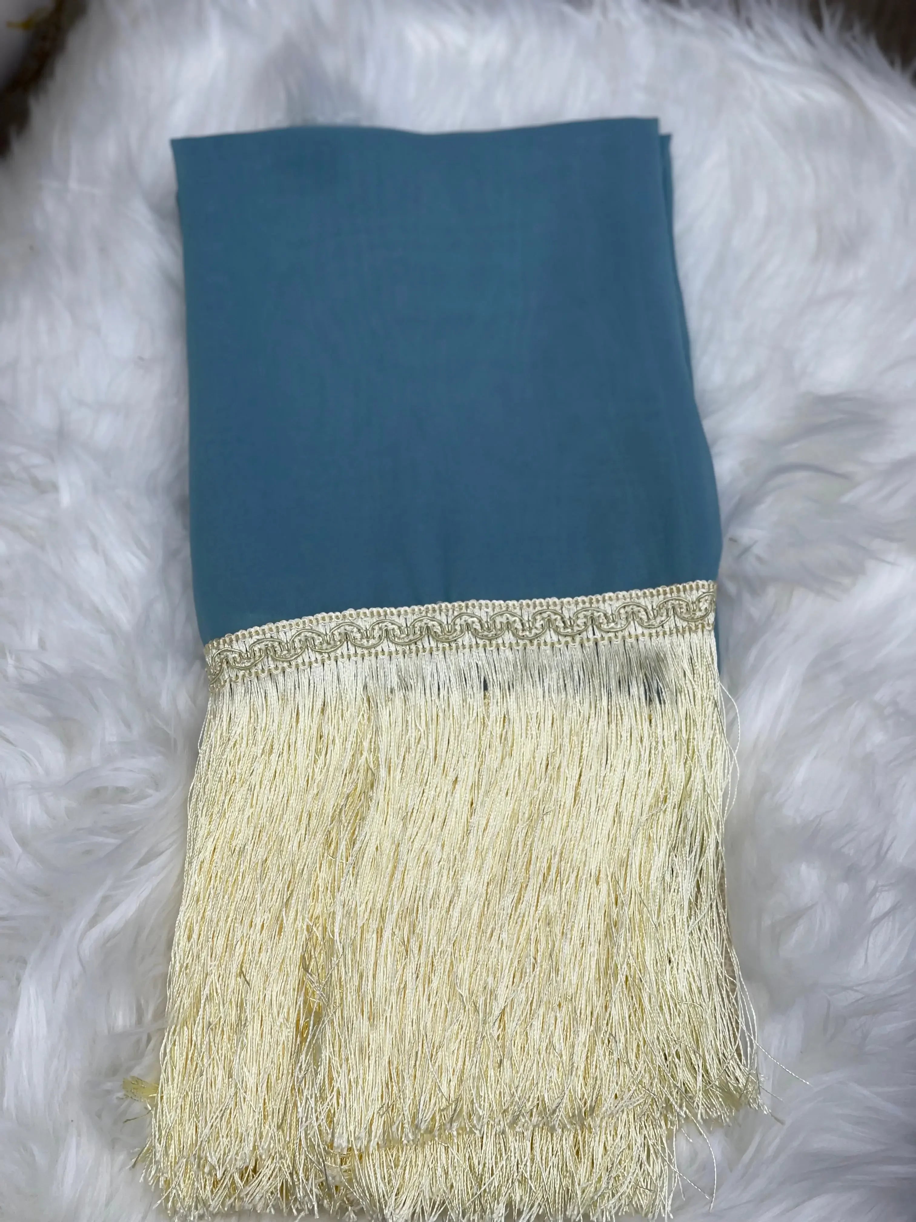 Traditional Palestinian khirka shawl with teal fabric and cream-colored fringes by Palestinian Elegance