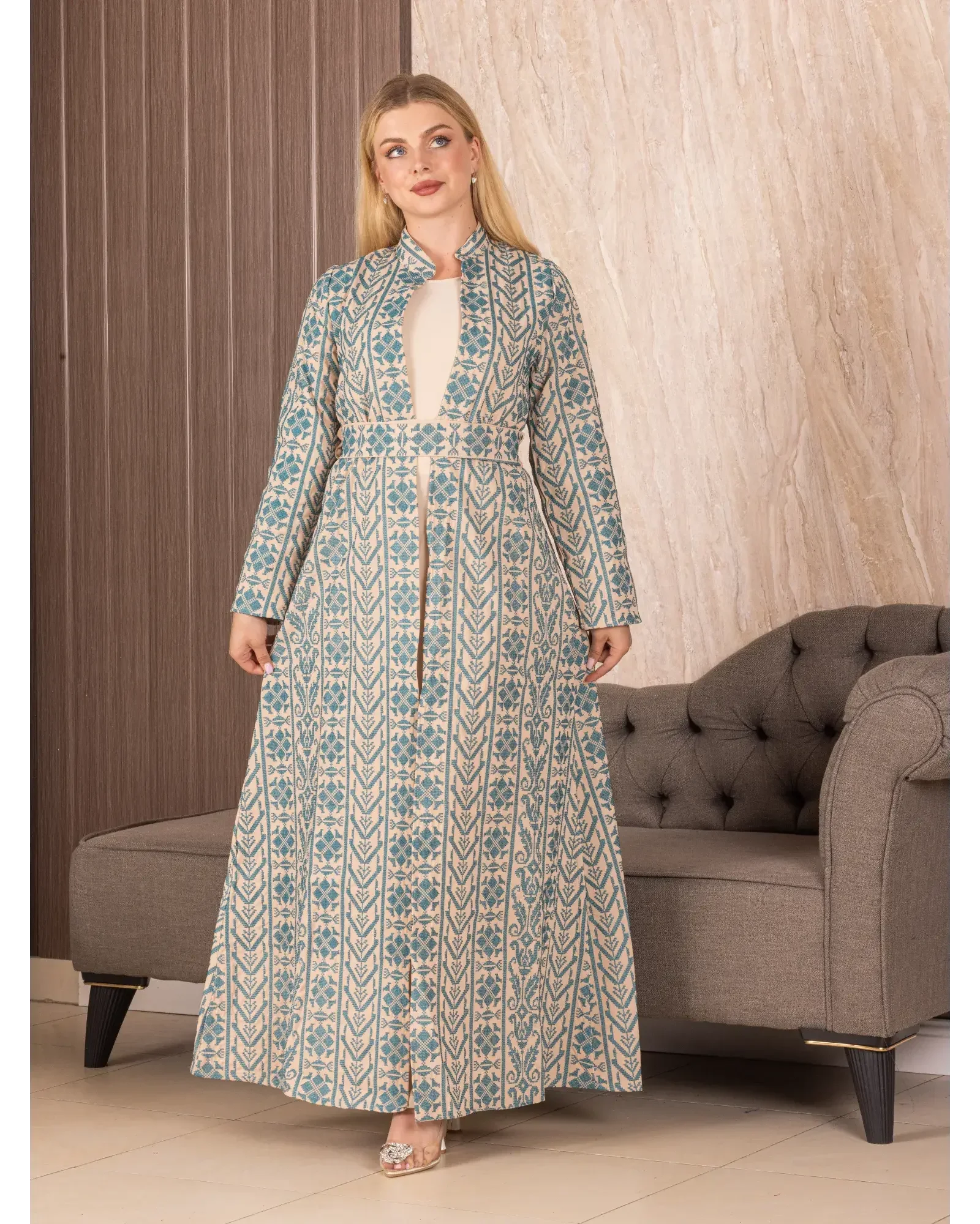 Palestinian Elegance embroidered long cardigan with blue and beige intricate patterns worn by woman indoors