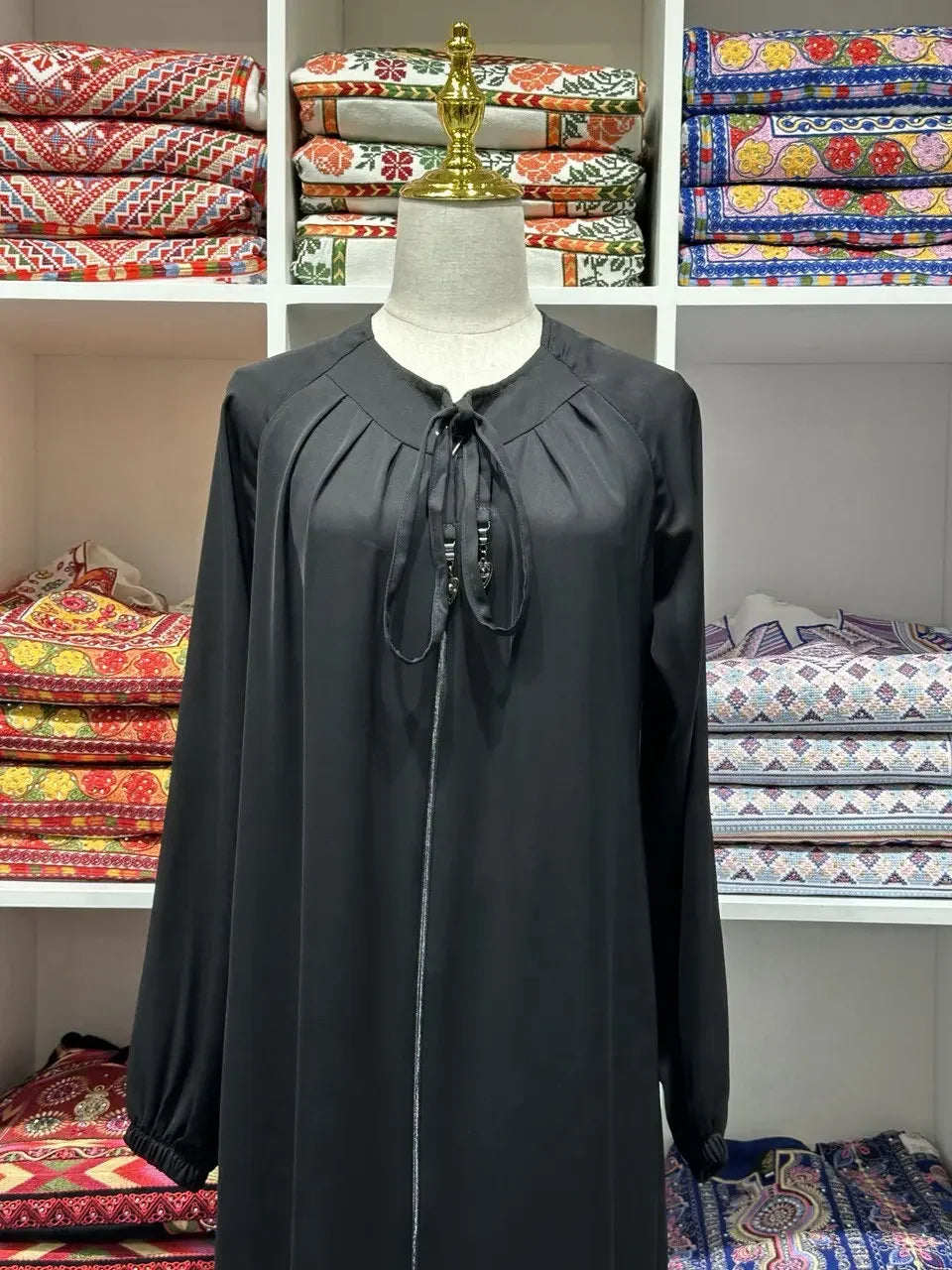 Black umra abaya for women with pleated neckline and tie detail by Palestinian Elegance