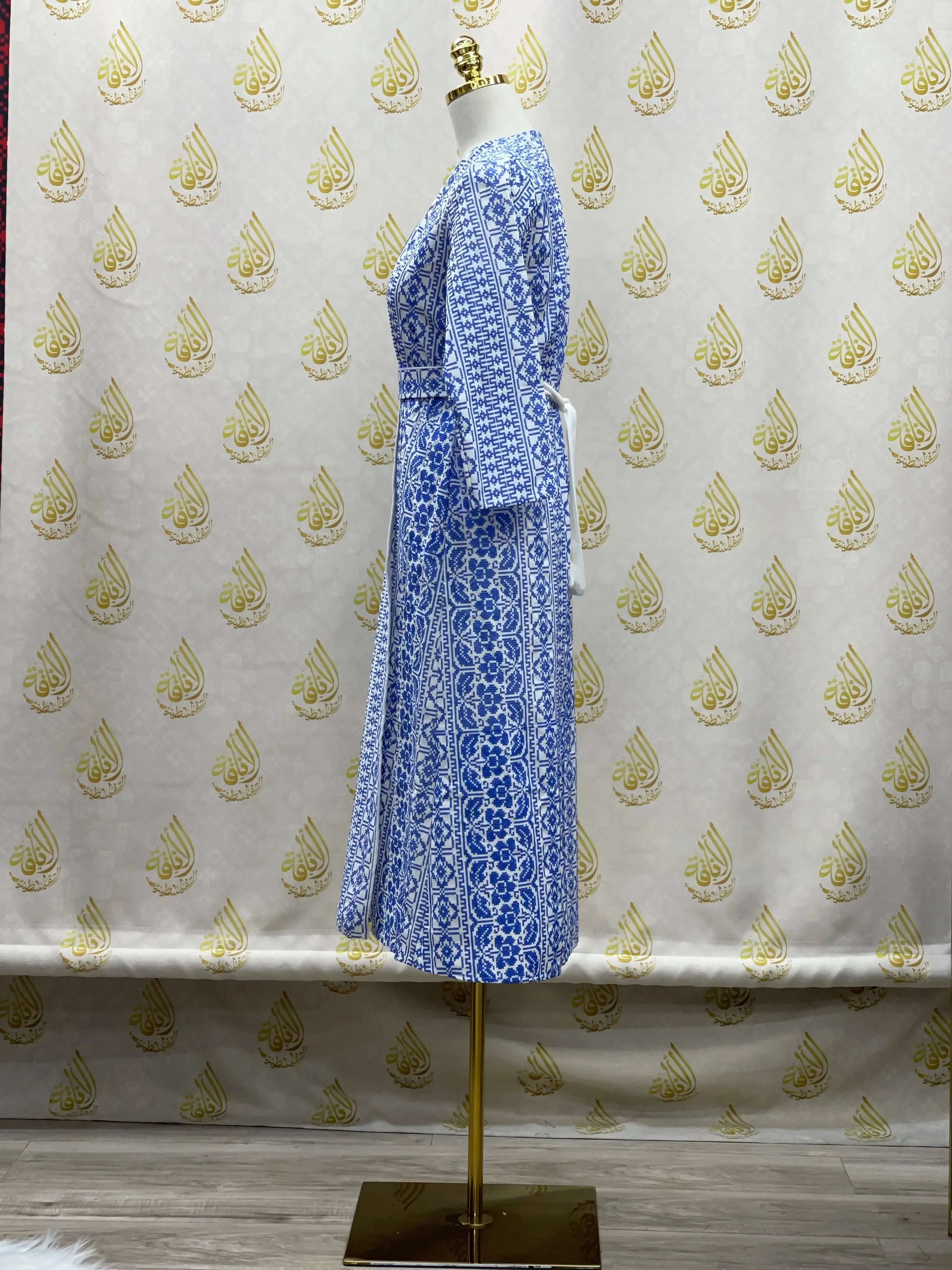 Side view of a blue and white embroidered cardigan for kids displayed on a mannequin with intricate floral patterns