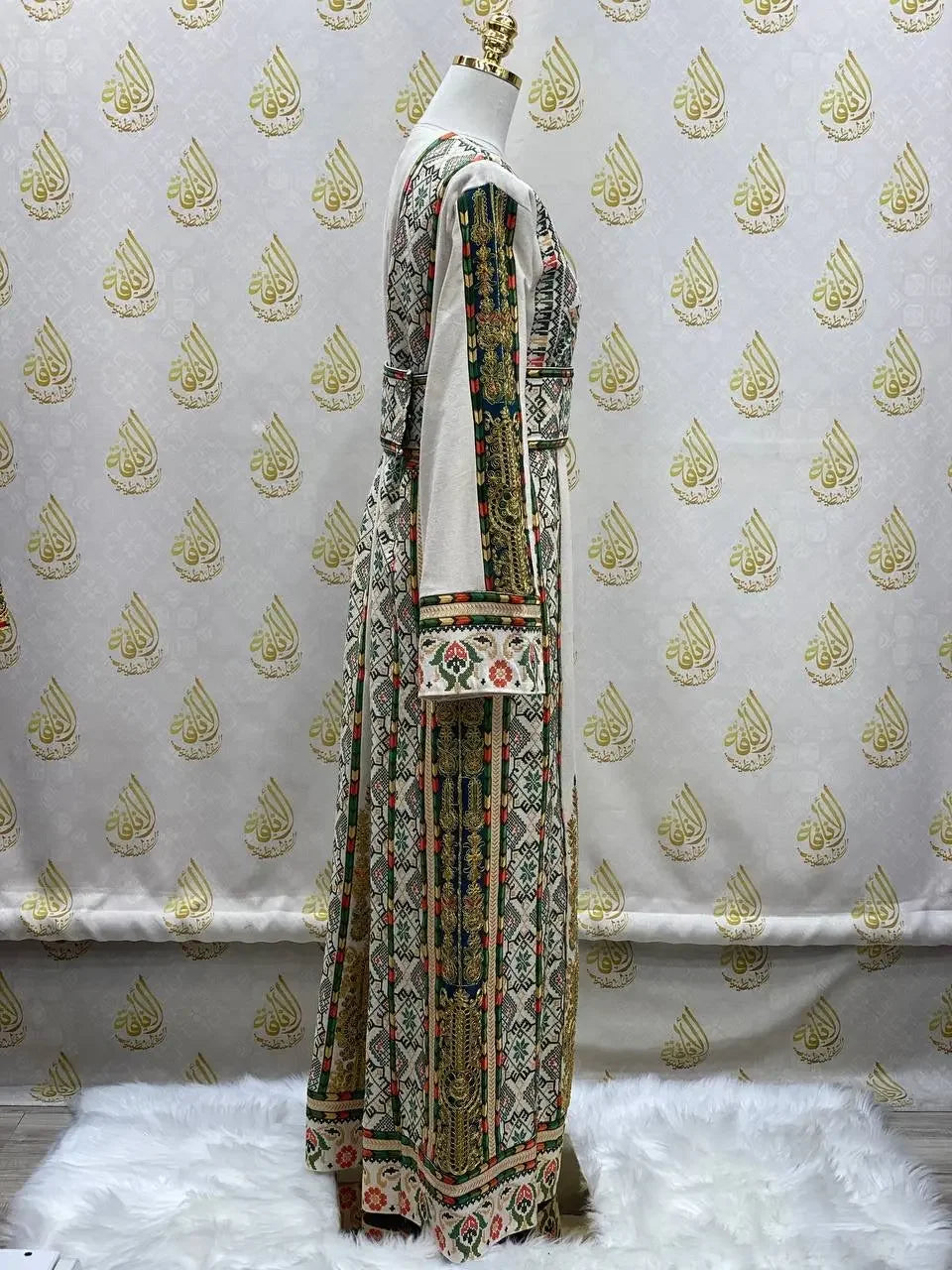 Side view of an embroidered Palestinian thobe with intricate traditional patterns displayed on a mannequin