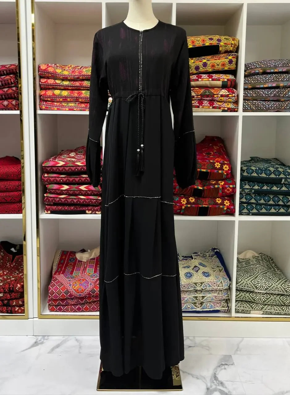 Palestinian Elegance modern abaya dress for women in black with long sleeves displayed on mannequin