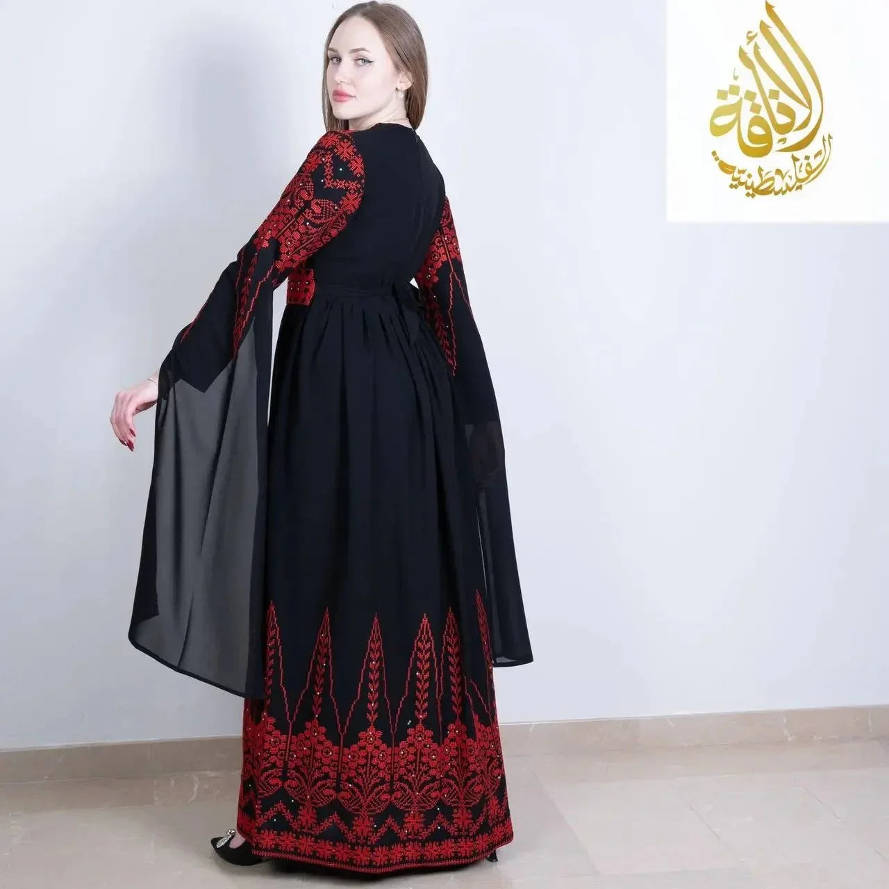 Elegant black Palestinian embroidered dress with red floral embroidery and flowing sleeves by Palestinian Elegance
