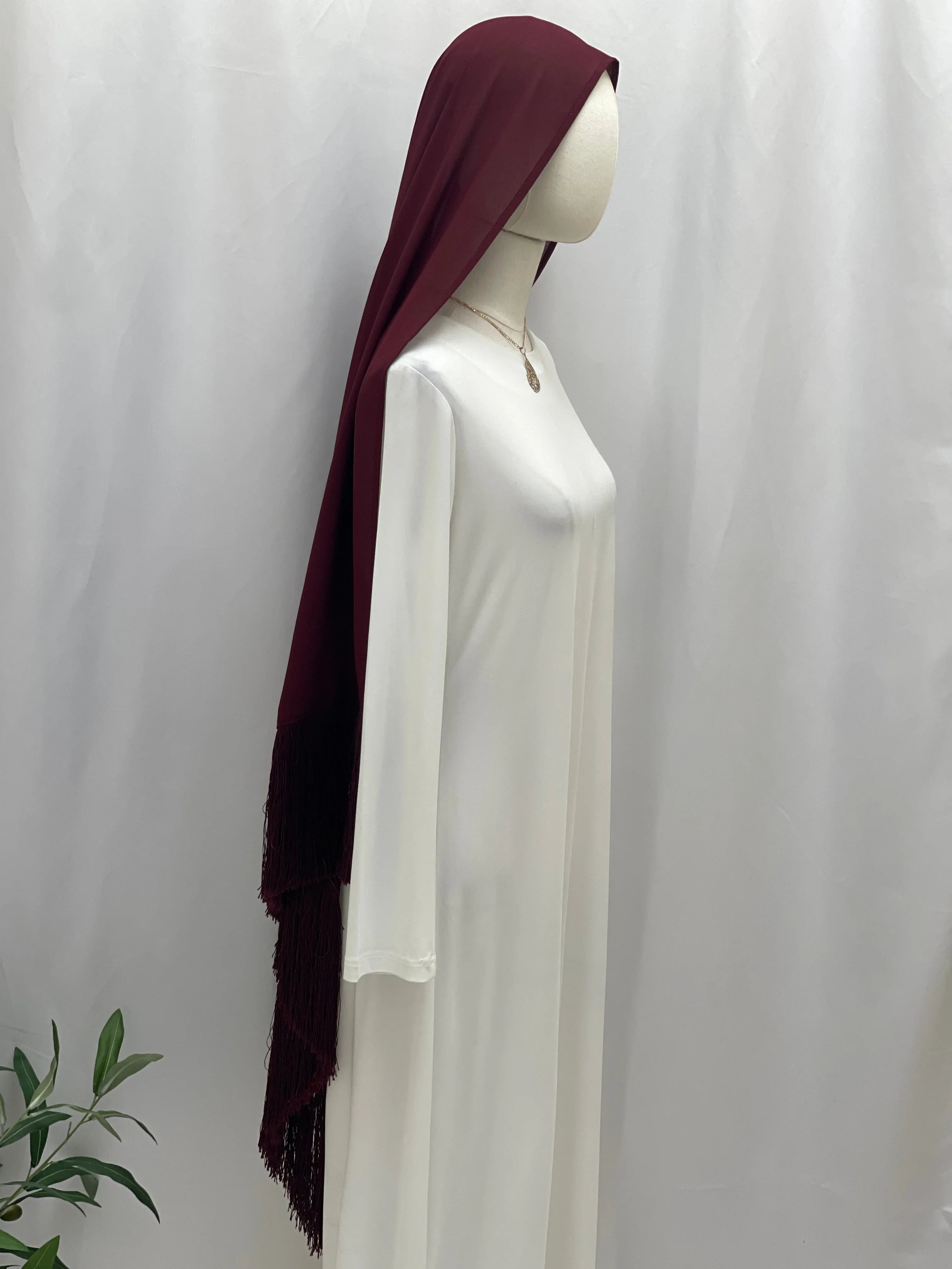 Mannequin wearing Dark Maroon Khirka With Tassel draped over white abaya side view with visible long tasseled hem