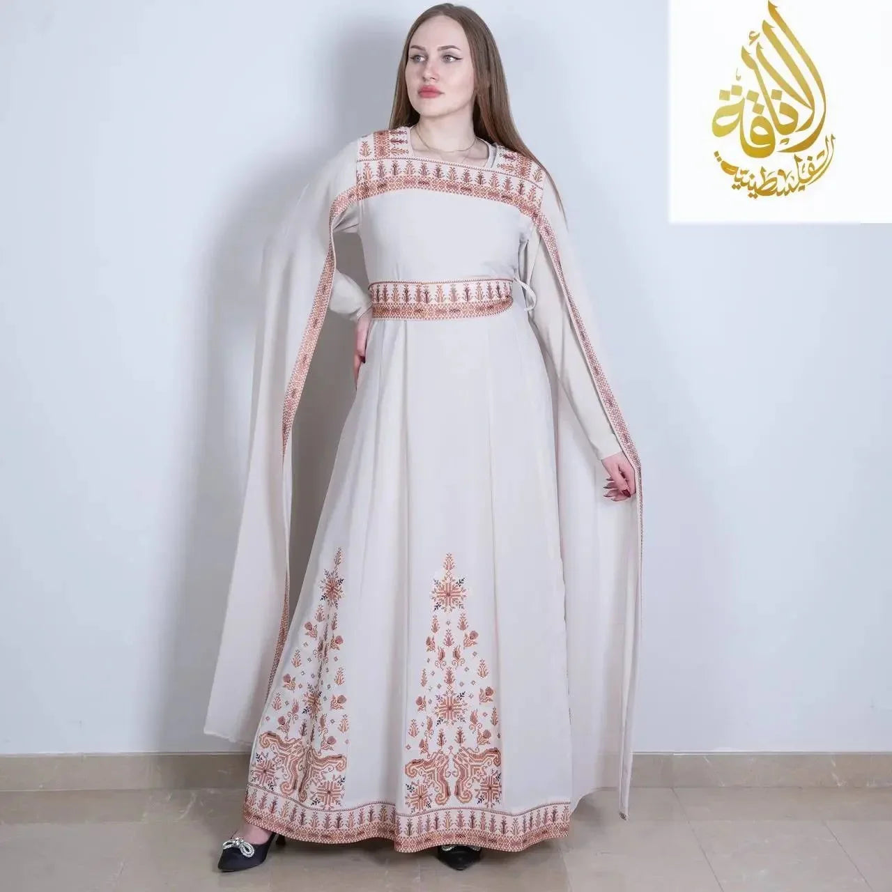 White embroidered Palestinian dress with traditional brown embroidery patterns and flowing sleeves