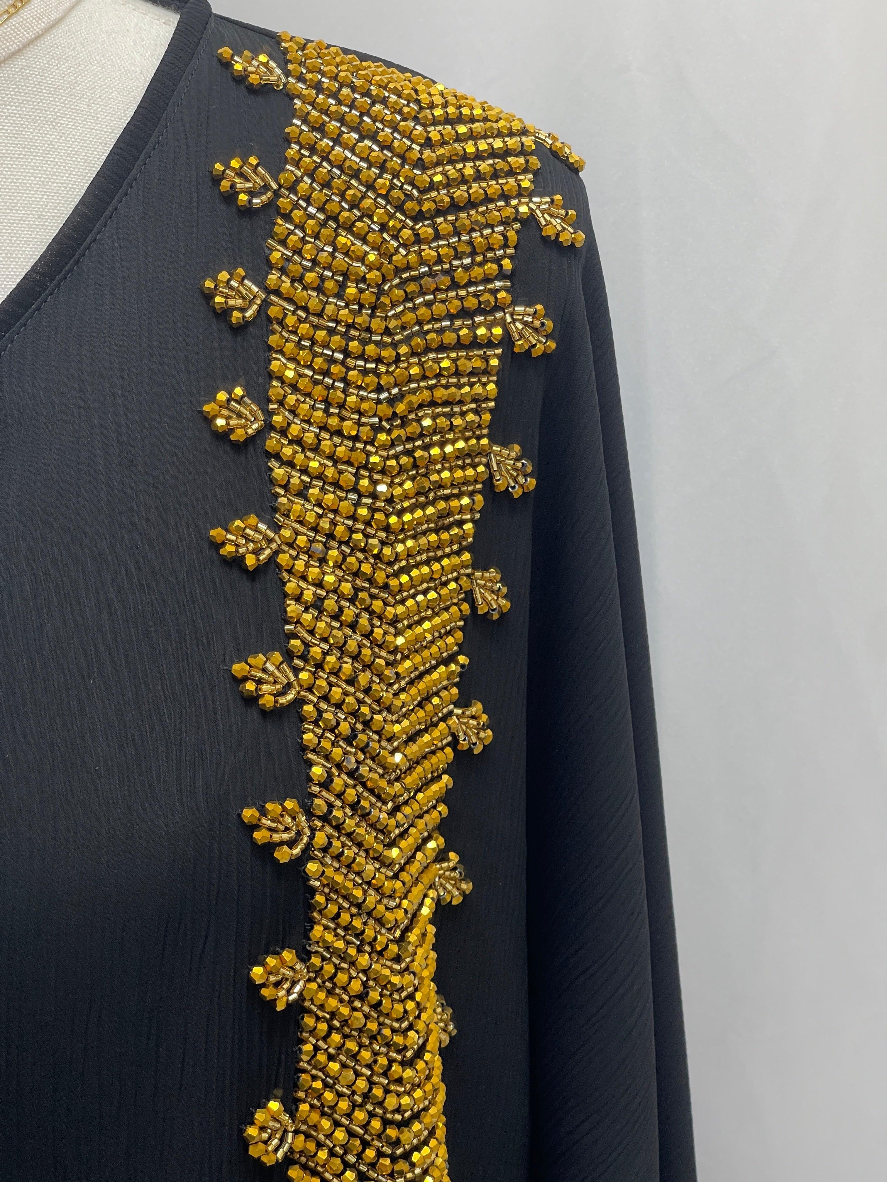 Black Palestinian Luxury Modest Fashion Abaya with detailed gold bead embellishments on the shoulder and front