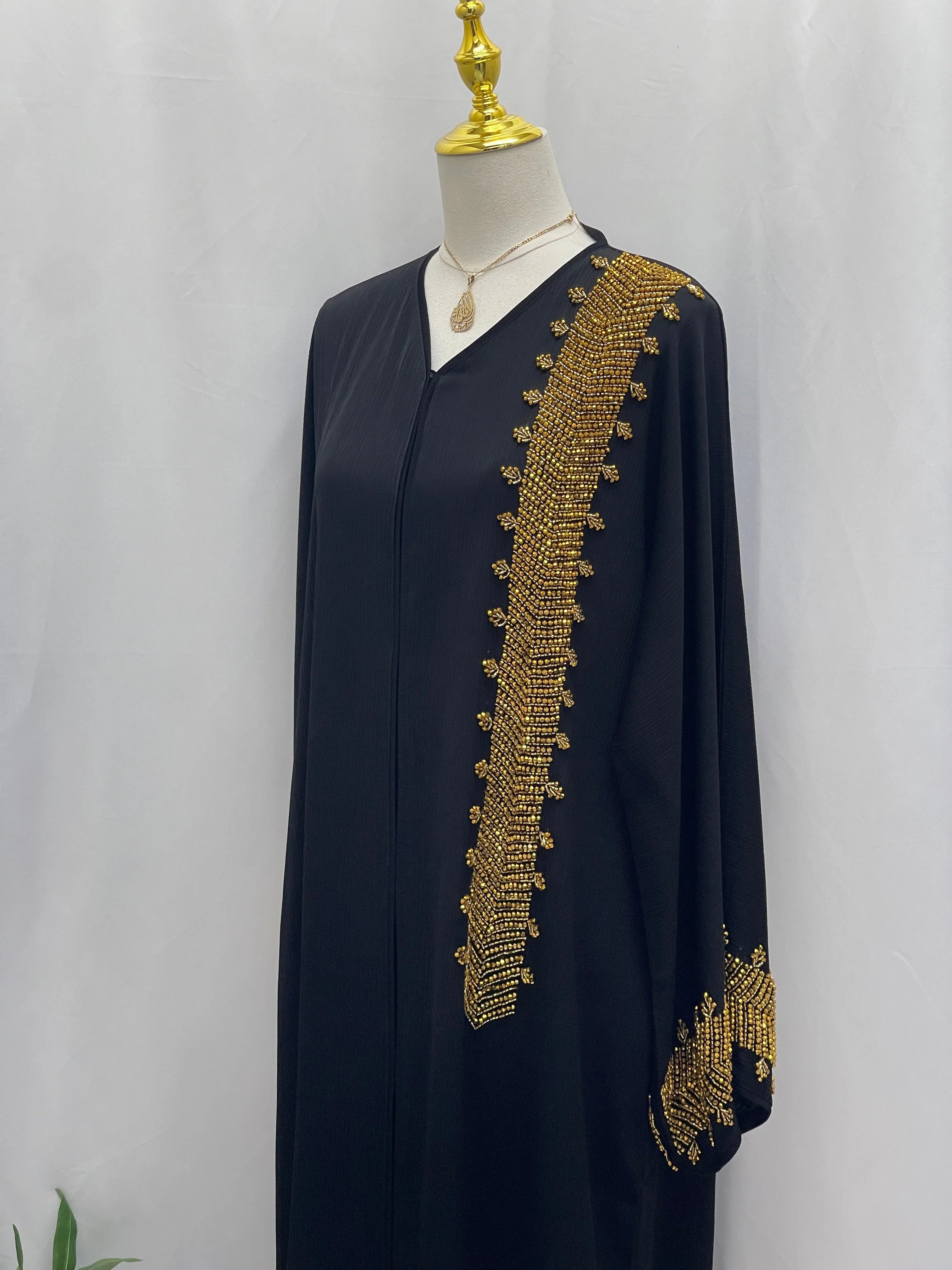Palestinian Luxury Modest Fashion Abaya in black with intricate gold embroidery on sleeve and front