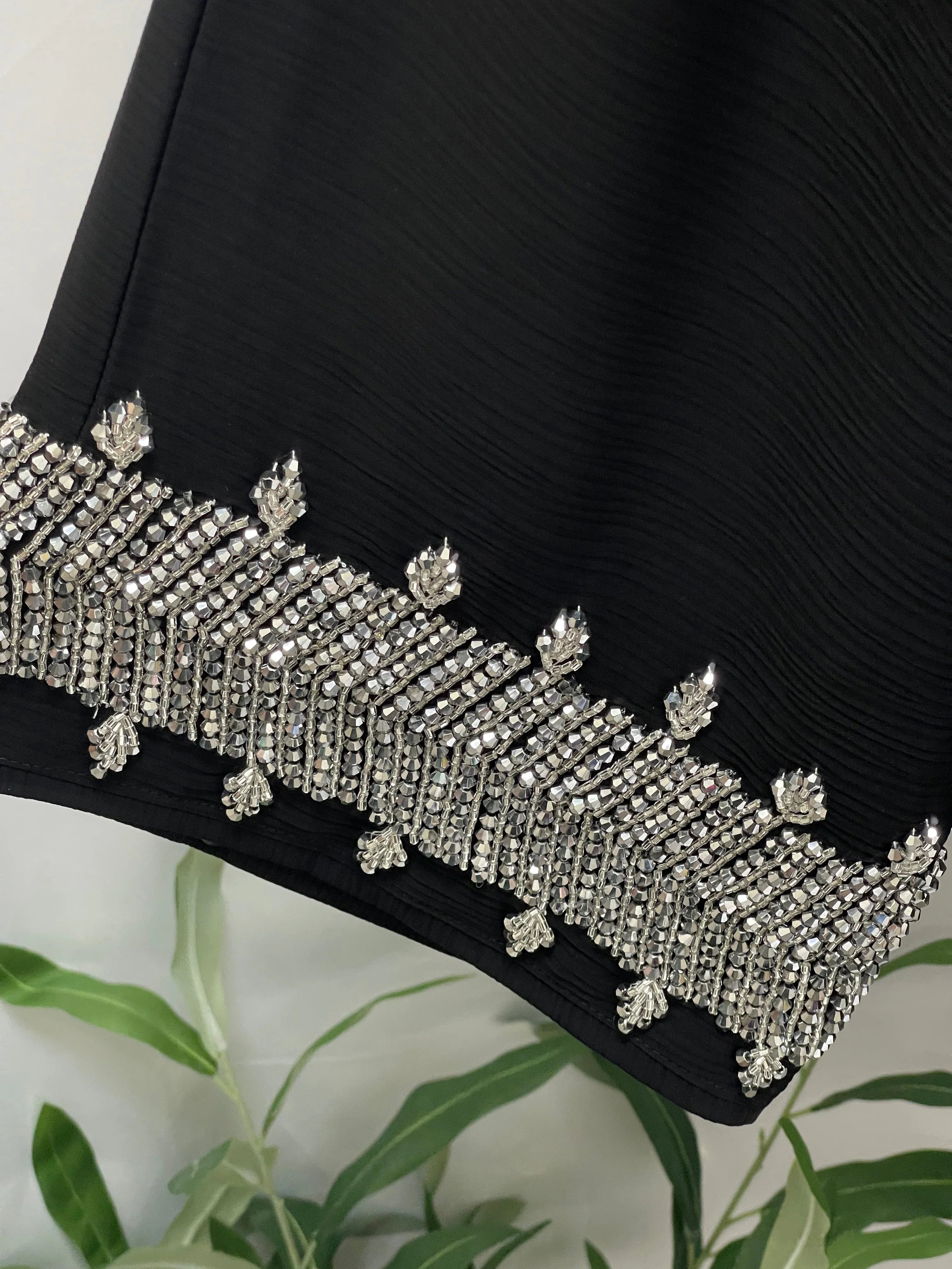Black Palestinian Luxury Modest Fashion Abaya with intricate silver bead embellishments on the hem by Palestinian Elegance