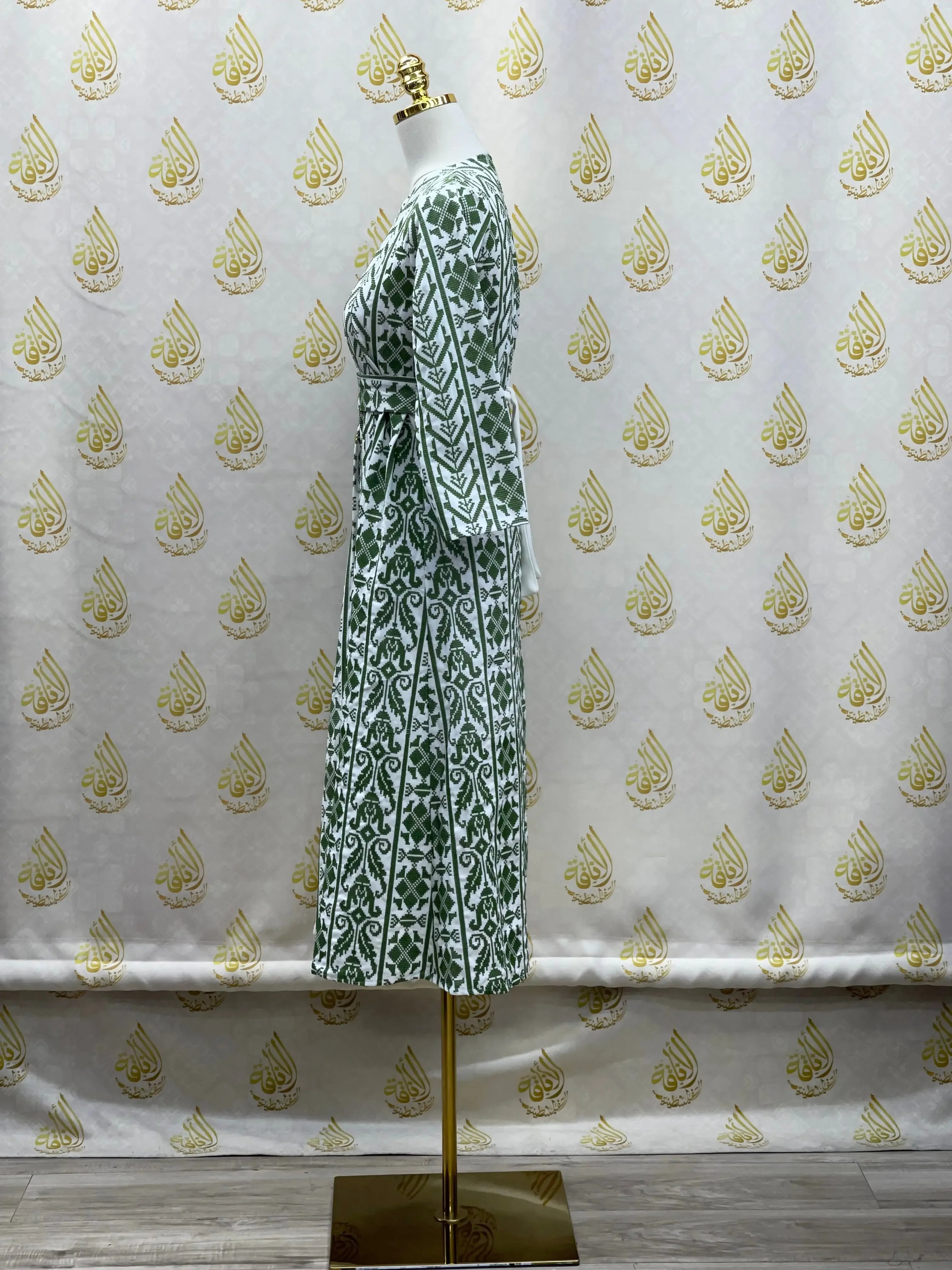 Palestinian Elegance embroidered cardigan for kids with green geometric floral patterns displayed on a mannequin