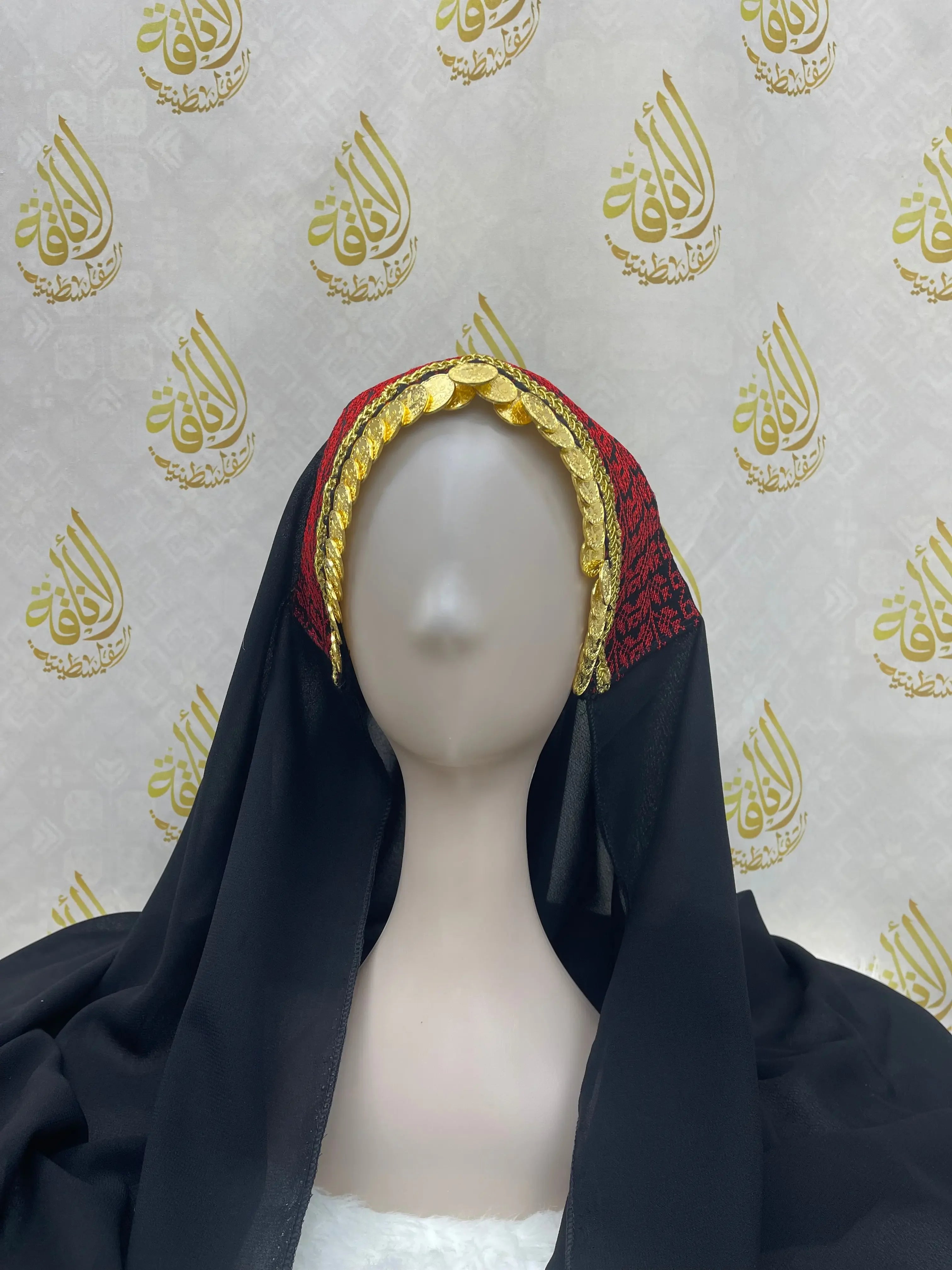 Palestinian embroidered khirka shawl in black with red and gold detailing worn on mannequin