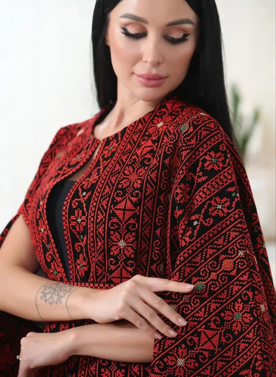 Palestinian Elegance embroidered cape jacket with traditional red and black patterns worn by woman