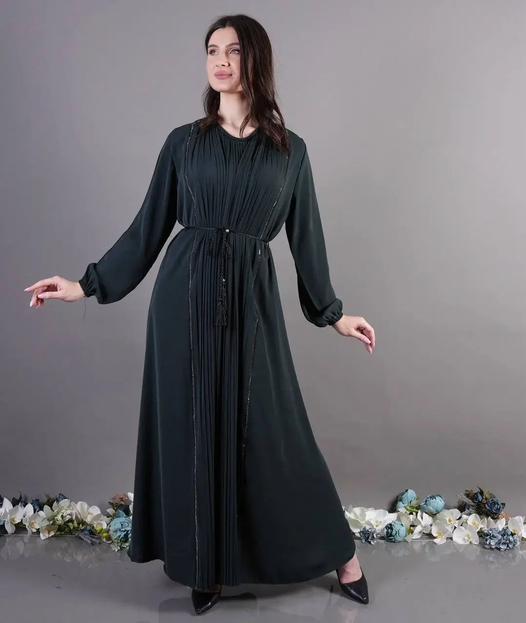 Palestinian Elegance black pleated abaya dress with long sleeves and waist tie belt on model