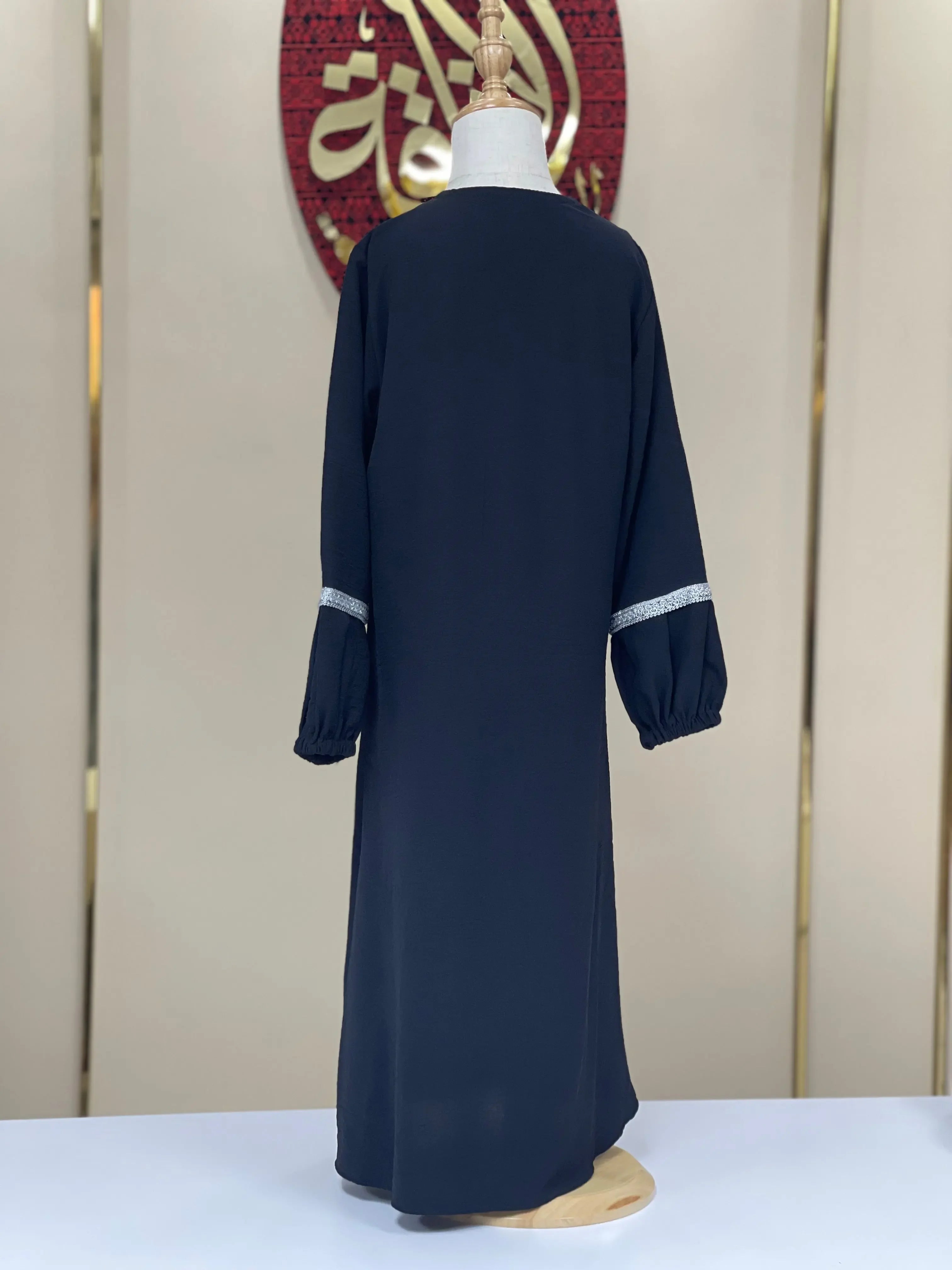Back view of girls embroidered abaya in navy blue with silver detailing on sleeves for kids by Palestinian Elegance