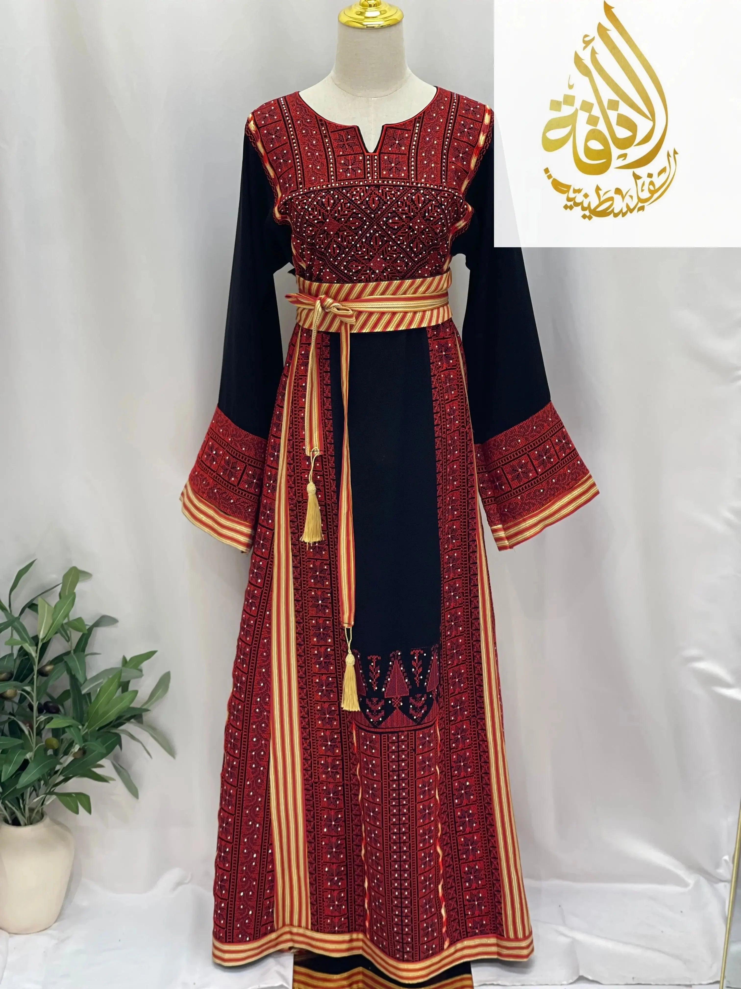 Embroidered Palestinian thoub dress by Palestinian Elegance with intricate red and black embroidery and striped waist belt