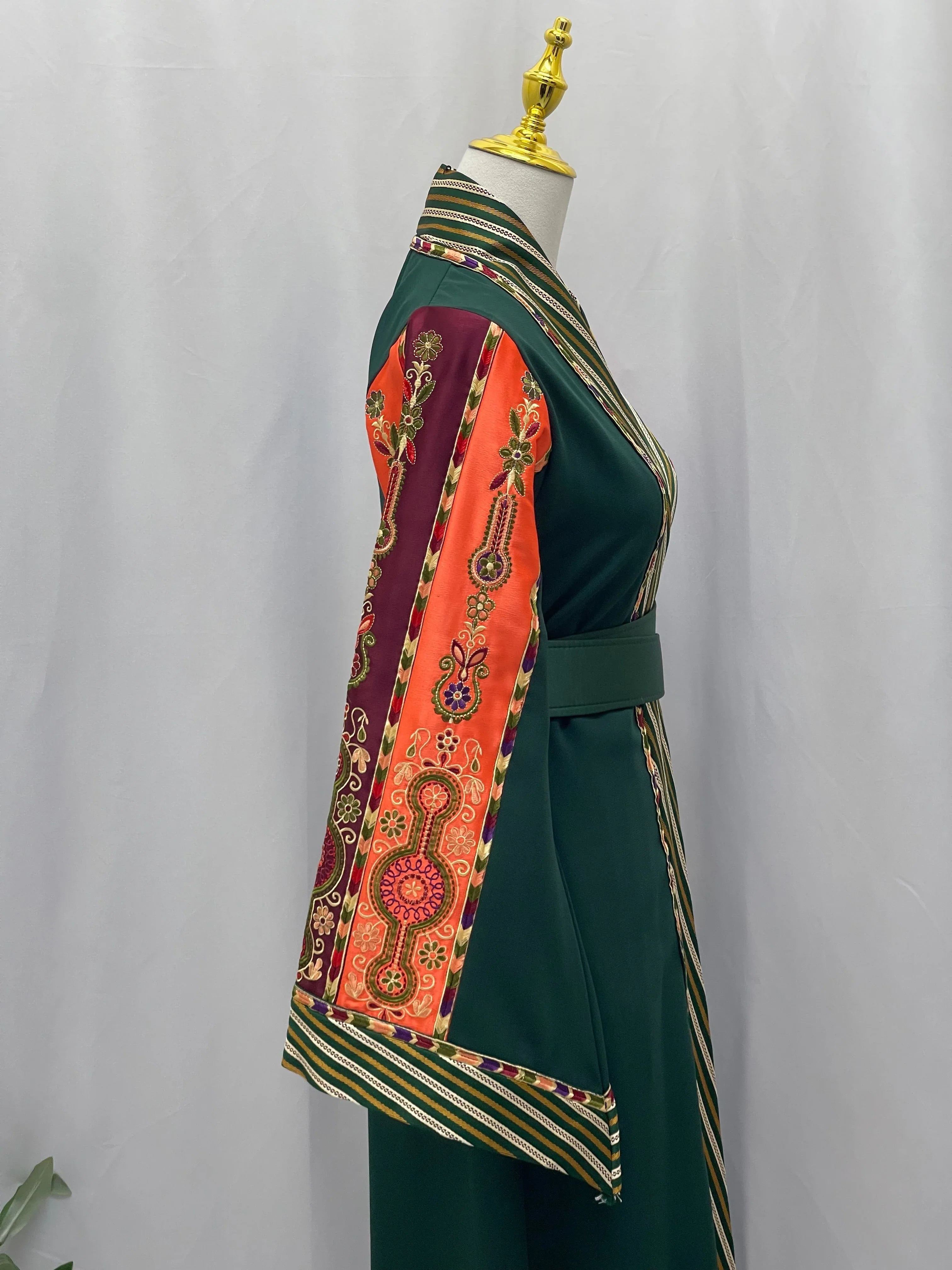 Palestinian Elegance green cardigan with vibrant embroidered sleeves showcasing elegant modest fashion bisht style