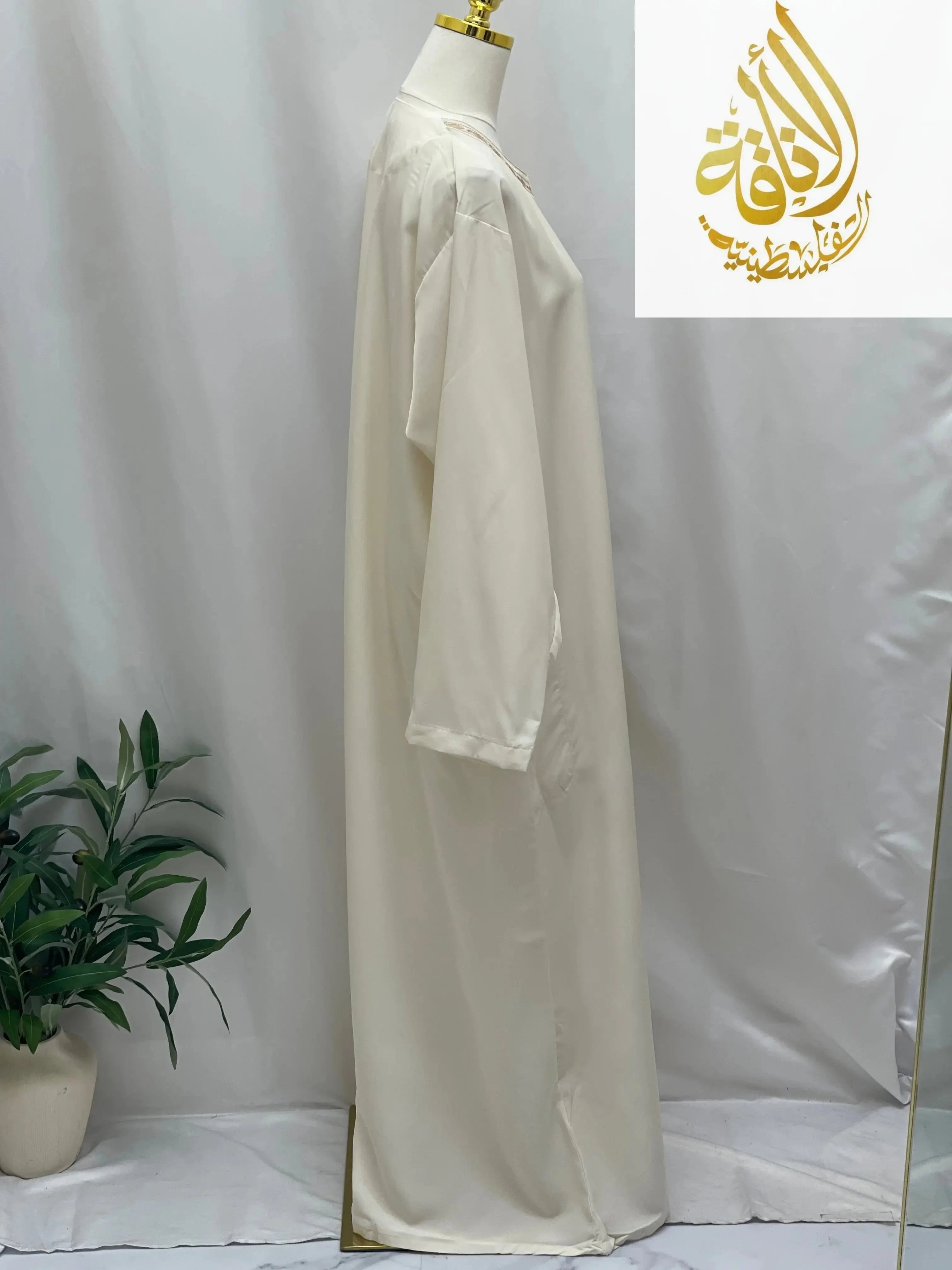 Palestinian Elegance men's embroidered thobe dress in white displayed on mannequin against white background