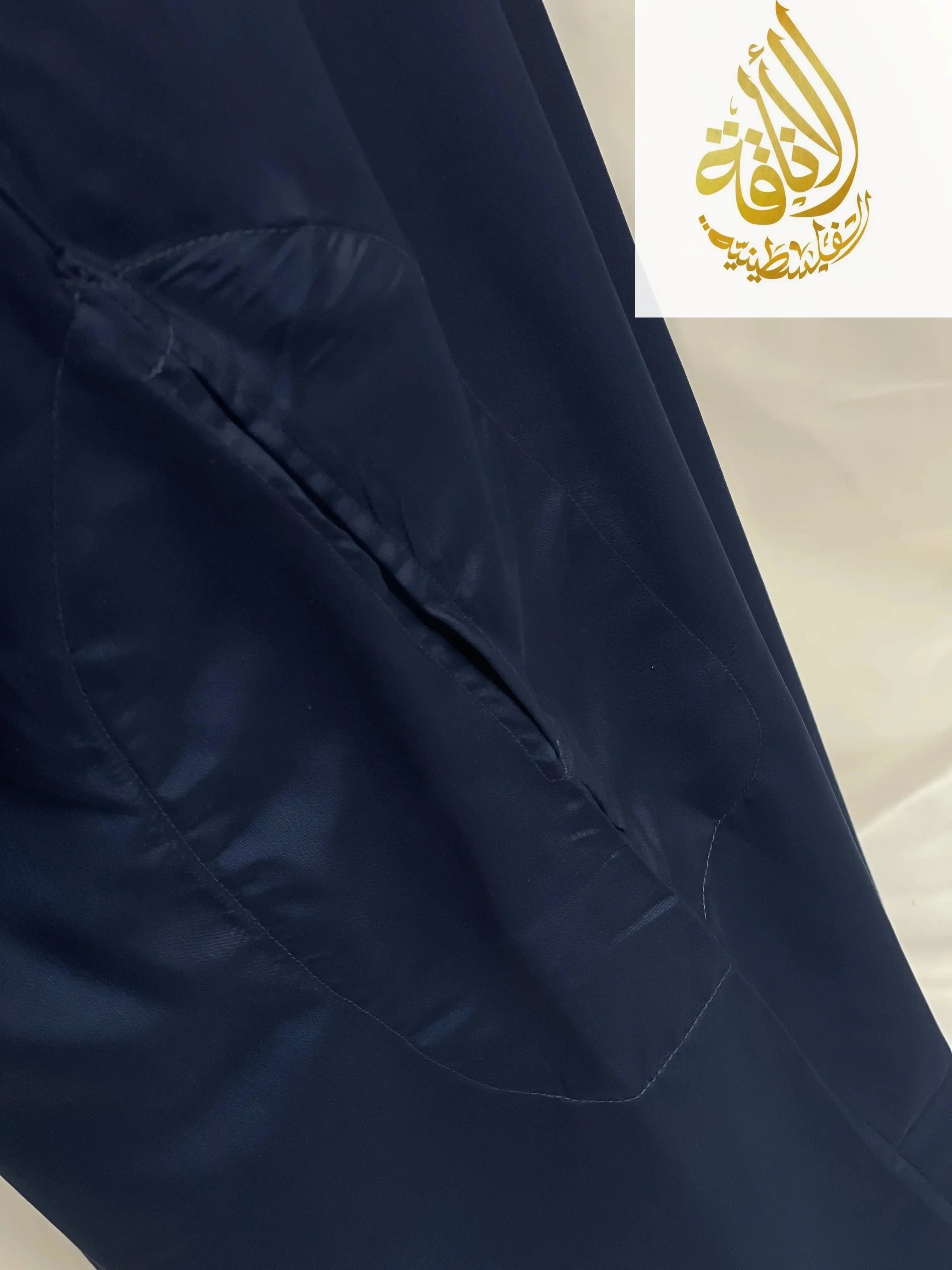 Close-up of navy blue embroidered thobe dress by Palestinian Elegance showing detailed fabric and pocket stitching