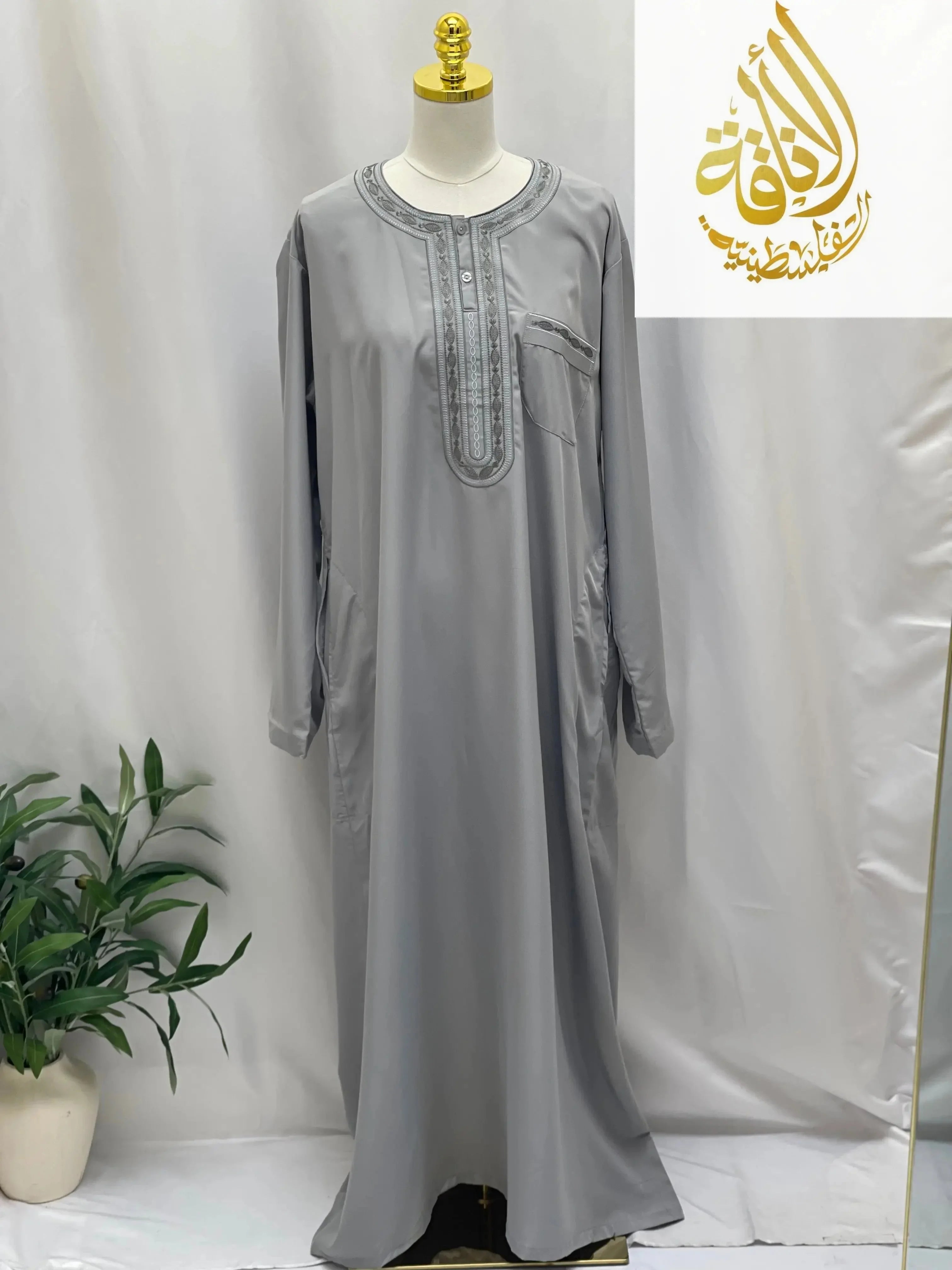 Gray men thobe by Palestinian Elegance featuring detailed embroidery around neckline and chest pocket embroidered thobe dress