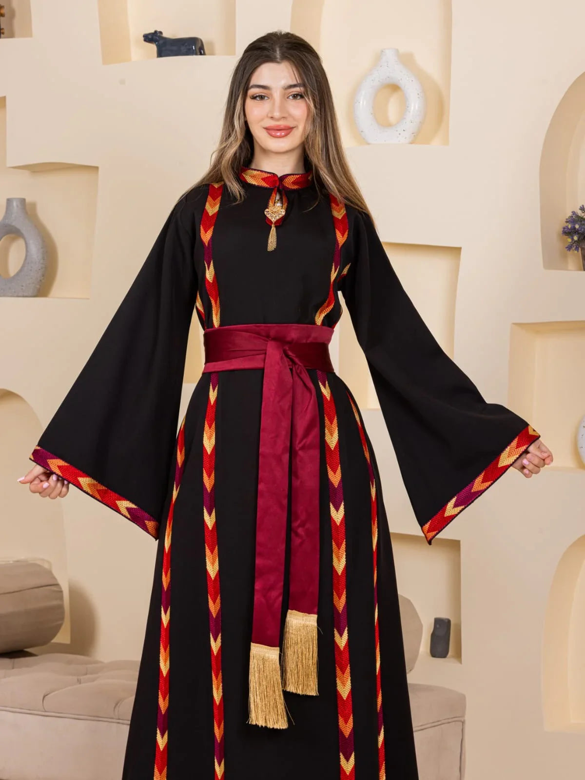 Palestinian Elegance Embroiderd Thoub Al-Manajel black embroidered thobe with maroon sash gold tassels and chevron trim