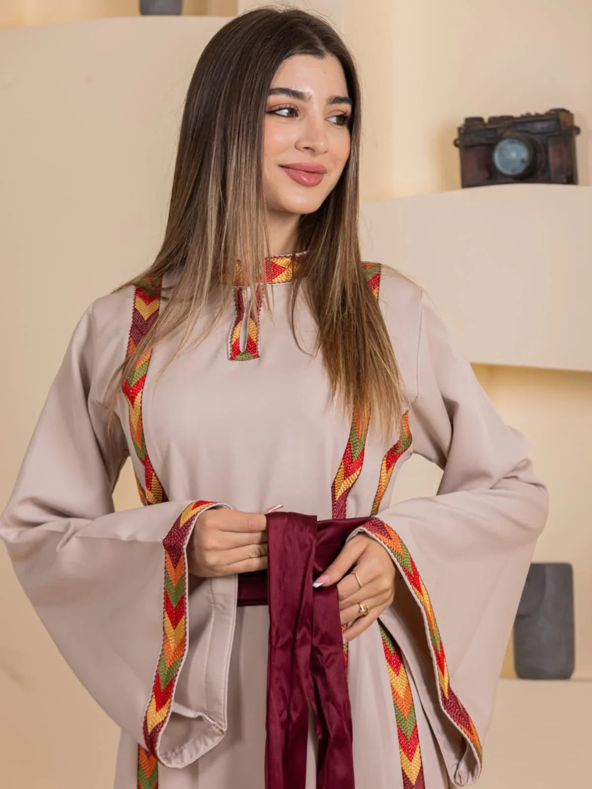 Palestinian Elegance Embroiderd Thoub Al-Manajel beige embroidered thobe with colorful woven trim and maroon sash