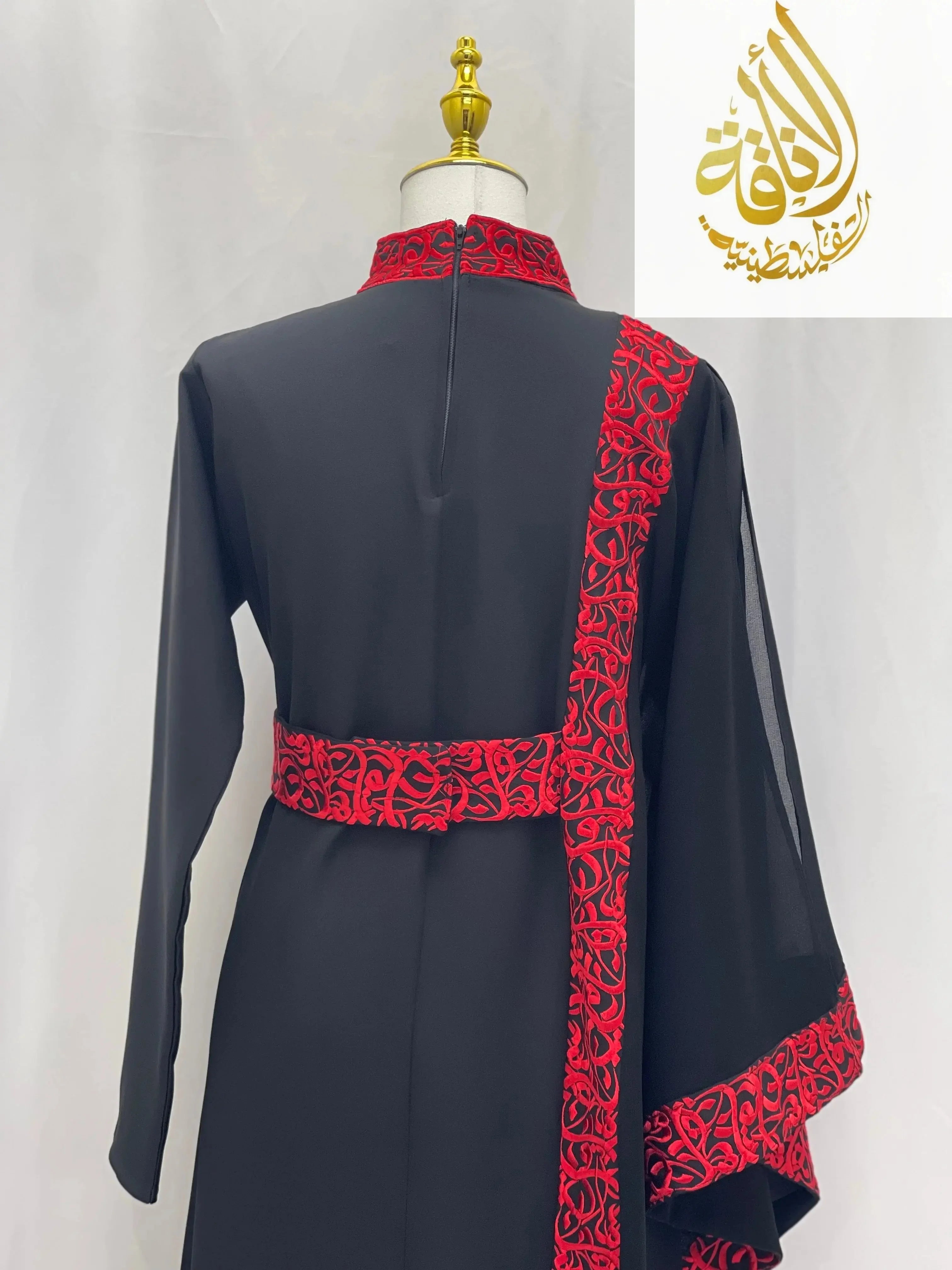 Palestinian Elegance black embroidered abaya with Arabic letters featuring red detailed embroidery on collar, belt, and sleeve edges
