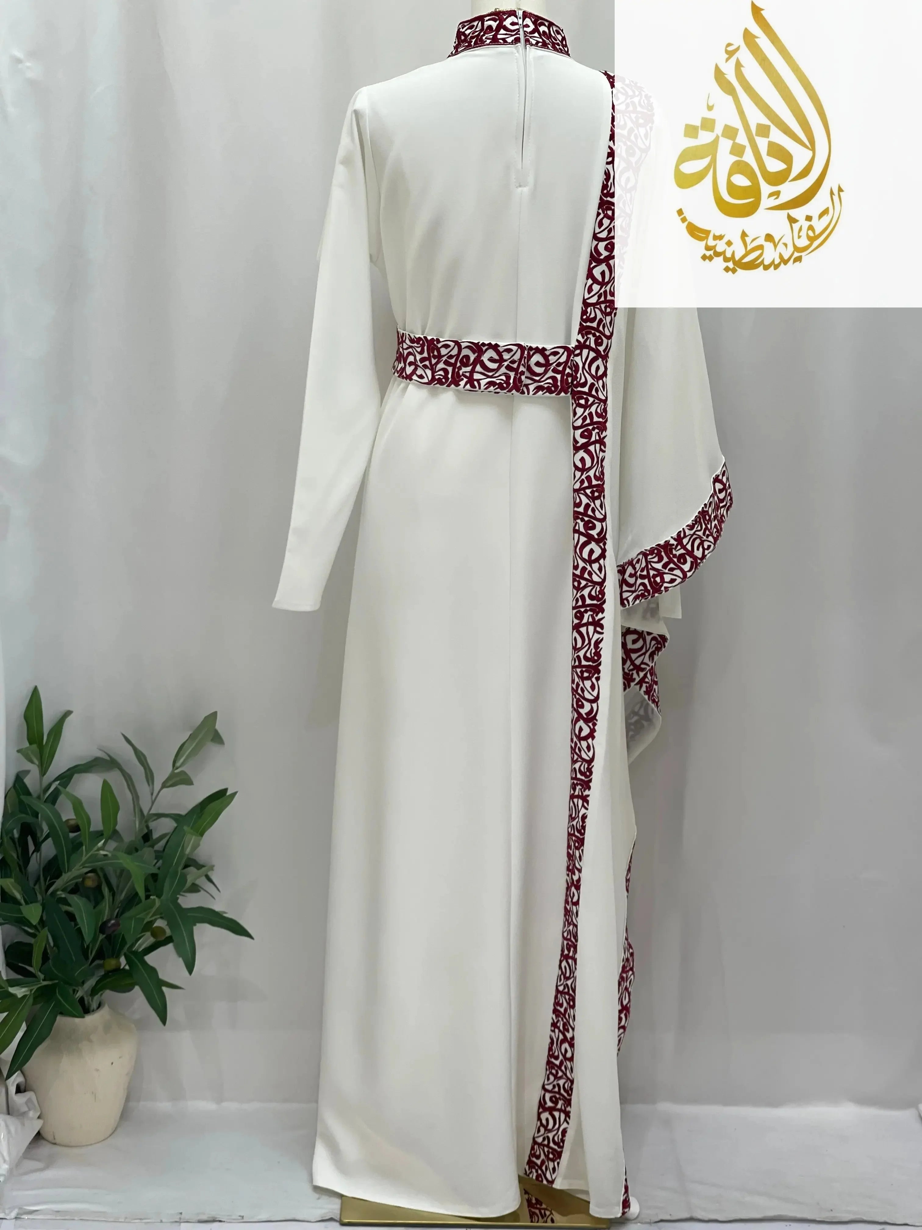 White embroidered abaya with Arabic letters and maroon detailed trim by Palestinian Elegance