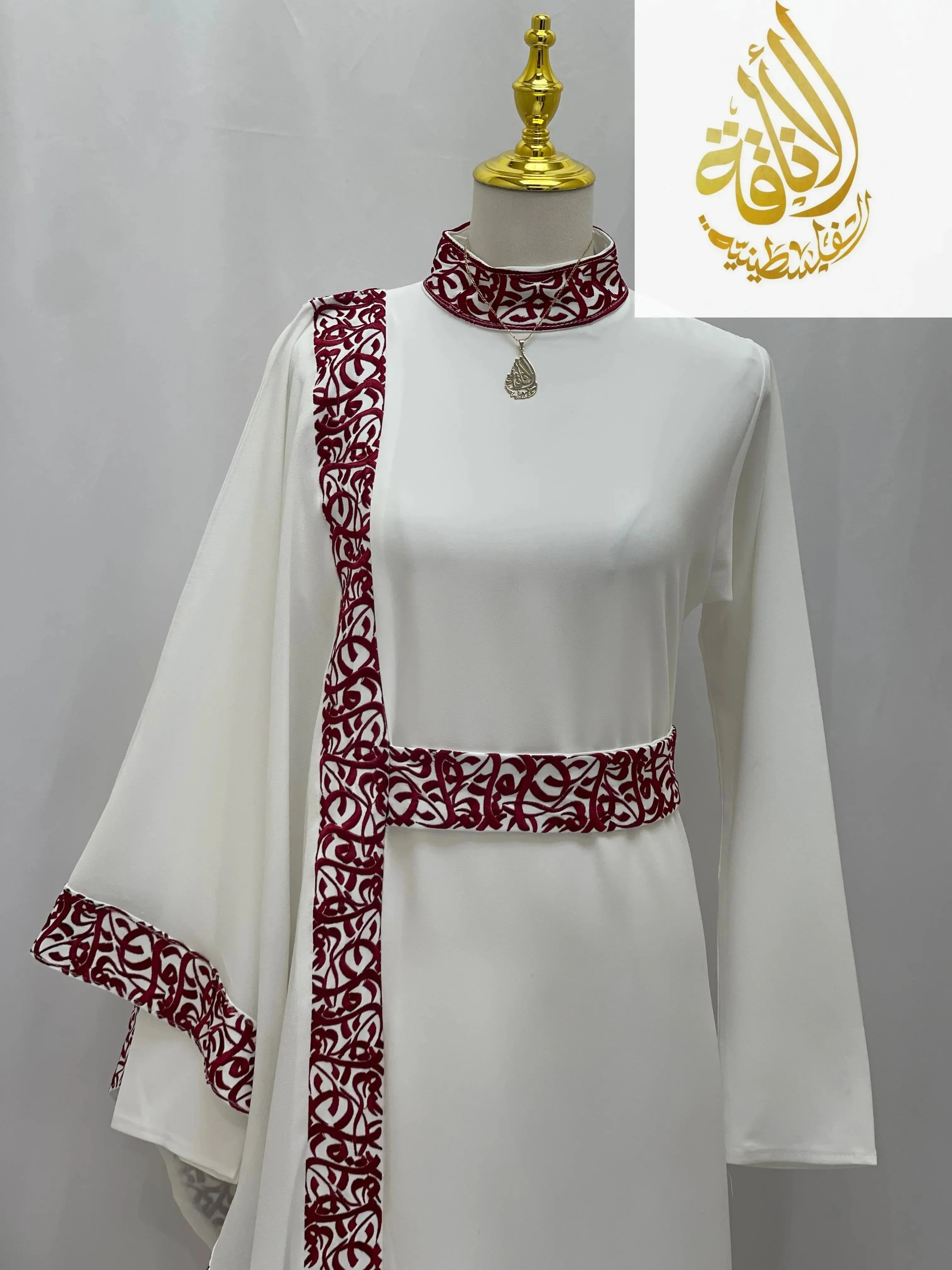 Palestinian Elegance embroidered abaya with Arabic letters in white with red detailed trim on collar, belt, and sleeve