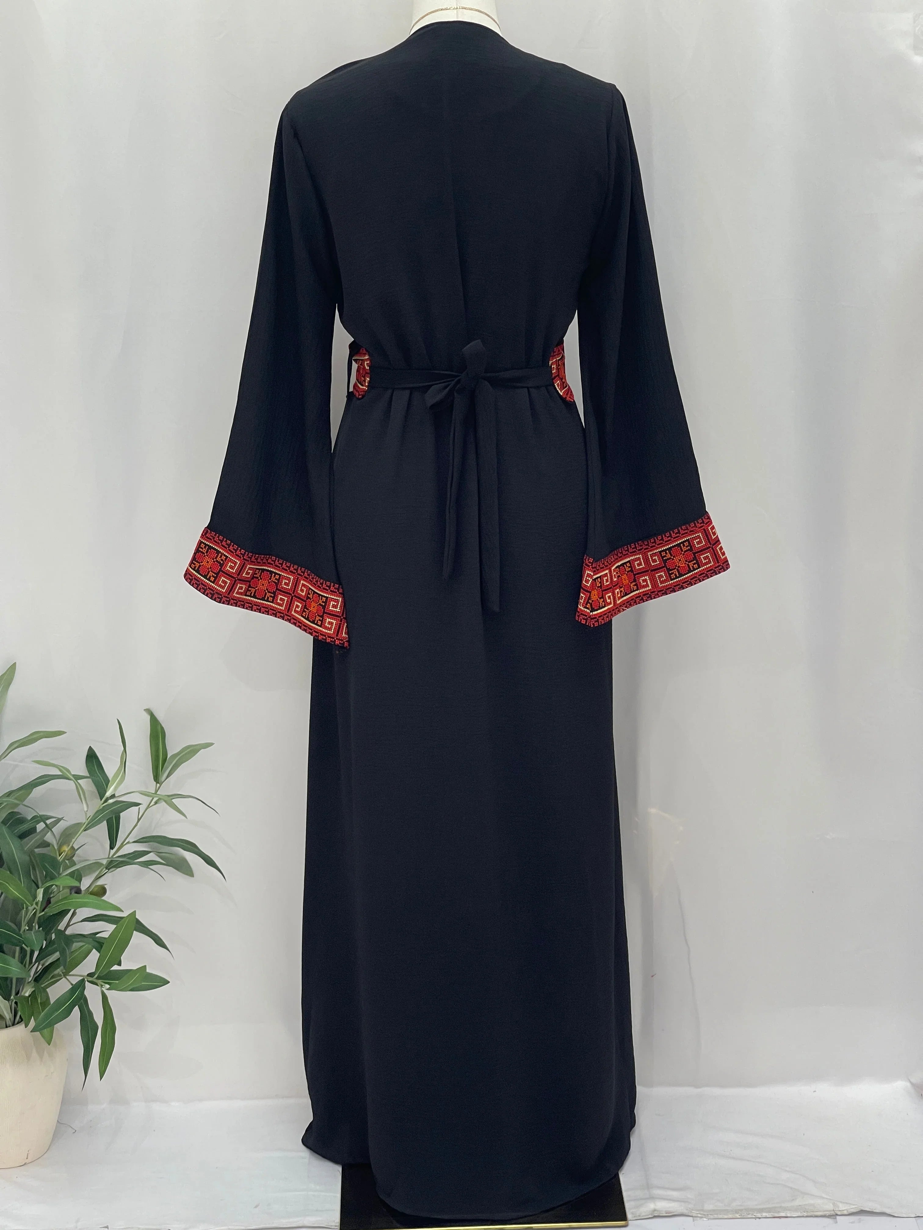 Palestinian Elegance black long Embroidered Cardigan back view on mannequin with red traditional embroidery cuffs and waist tie