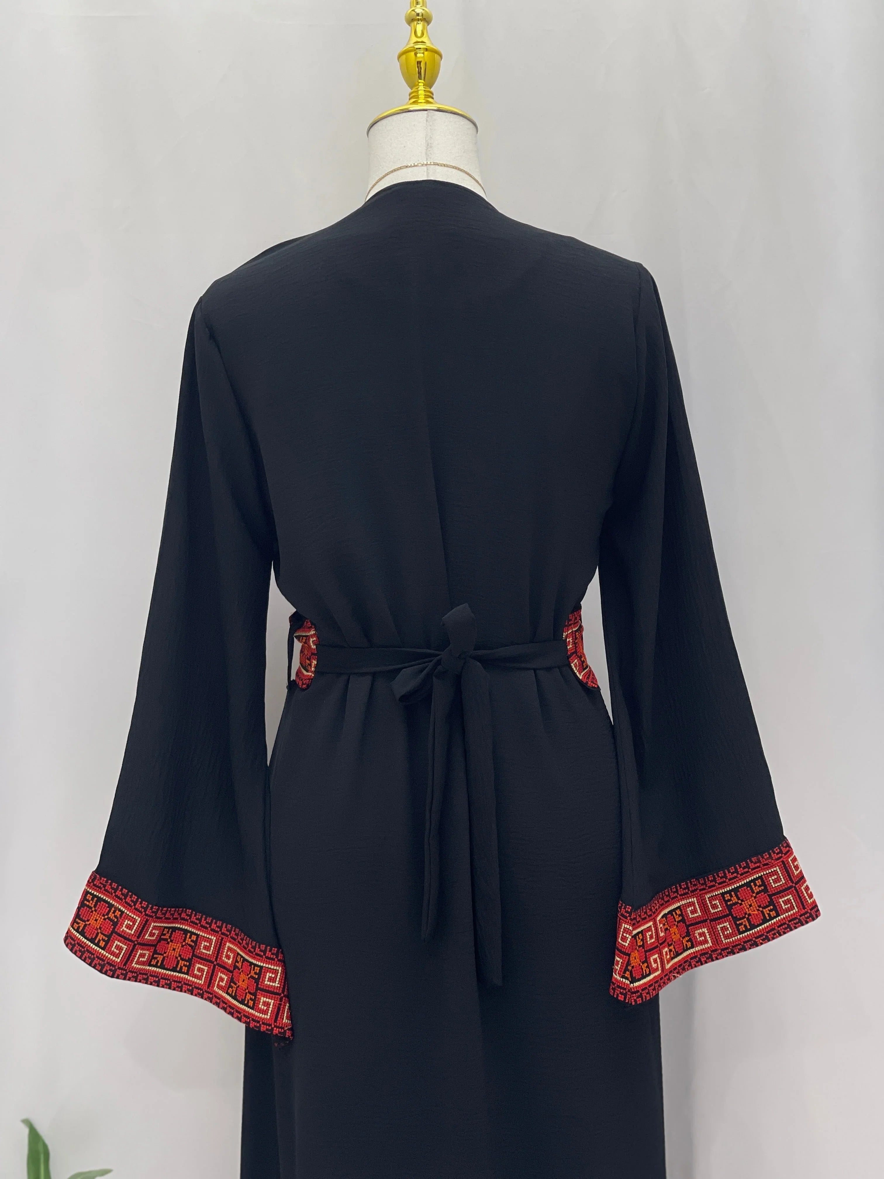 Palestinian Elegance black long Embroidered Cardigan back view with waist tie and red geometric embroidery on sleeve cuffs