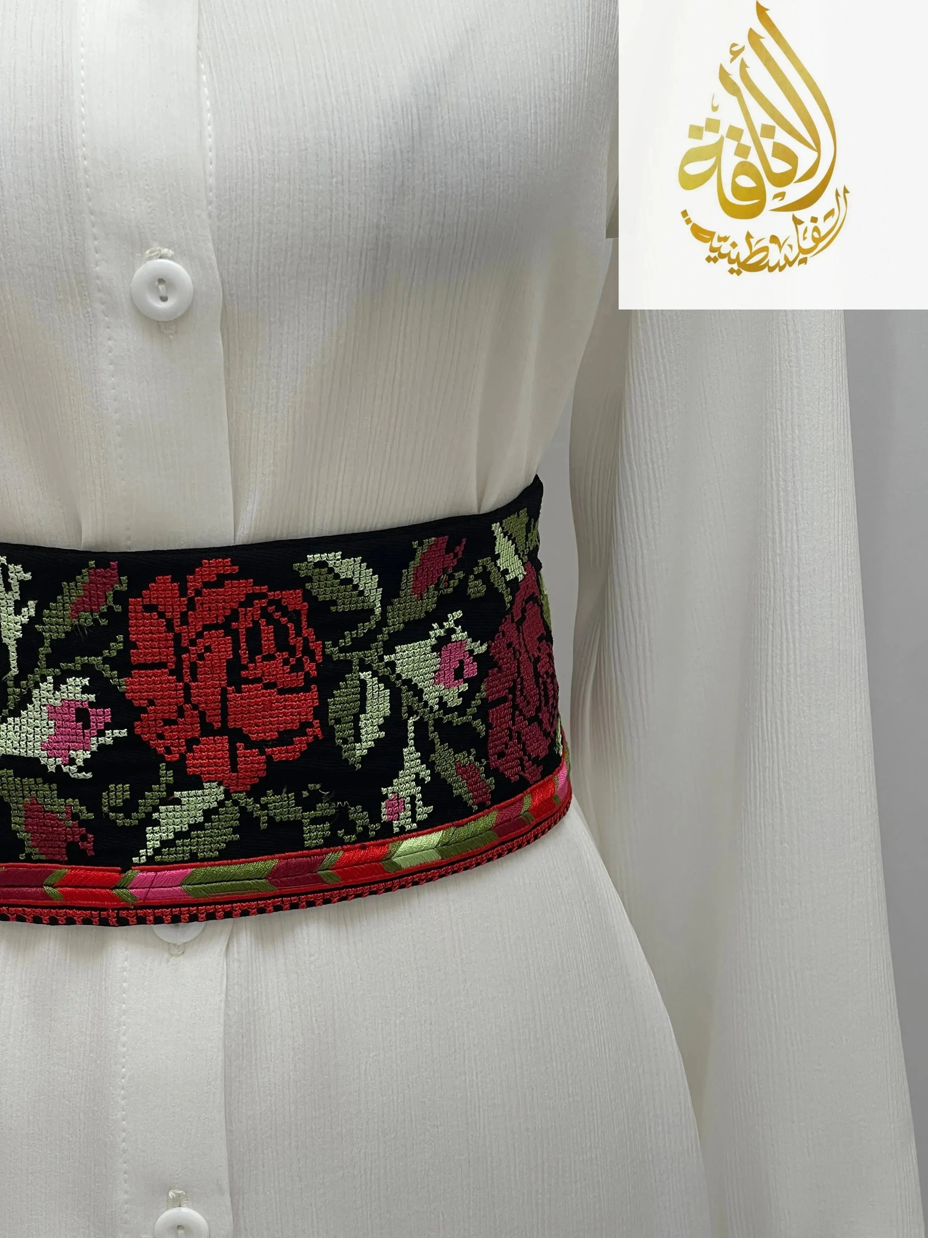 Palestinian Elegance Embroidered Heritage Belt with red roses and green leaves on black fabric worn over white dress