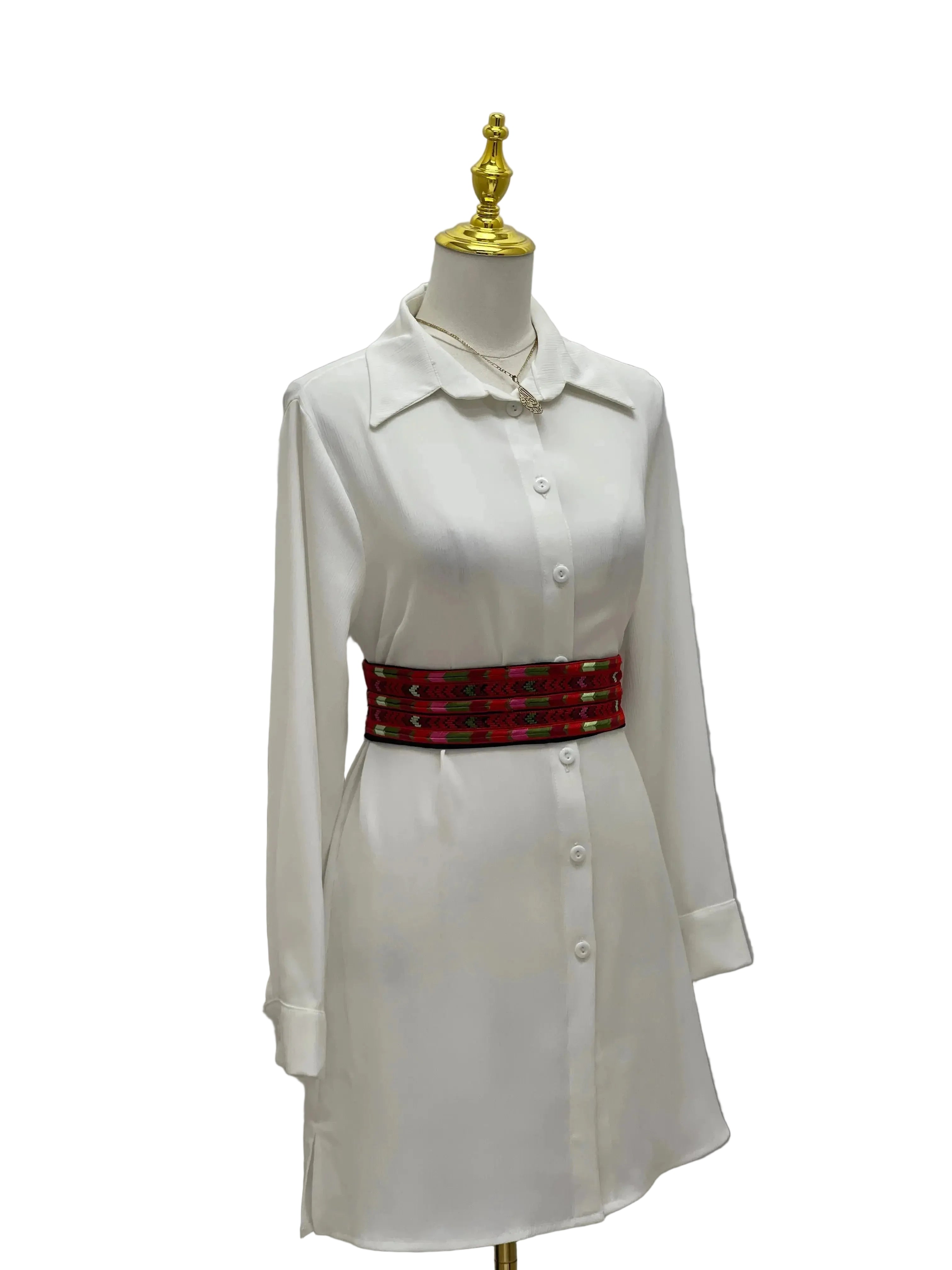 Embroidered Heritage Belt by Palestinian Elegance styled with a white button-up dress on a mannequin