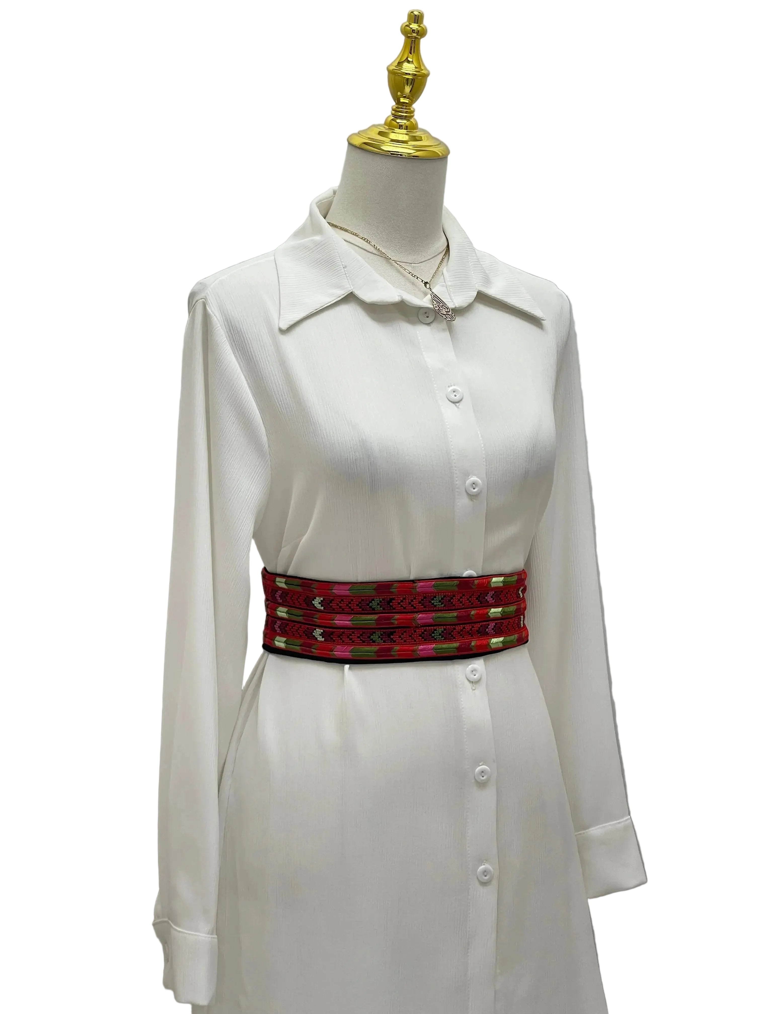 Palestinian Elegance Embroidered Heritage Belt in red with traditional patterns worn over white long sleeve dress