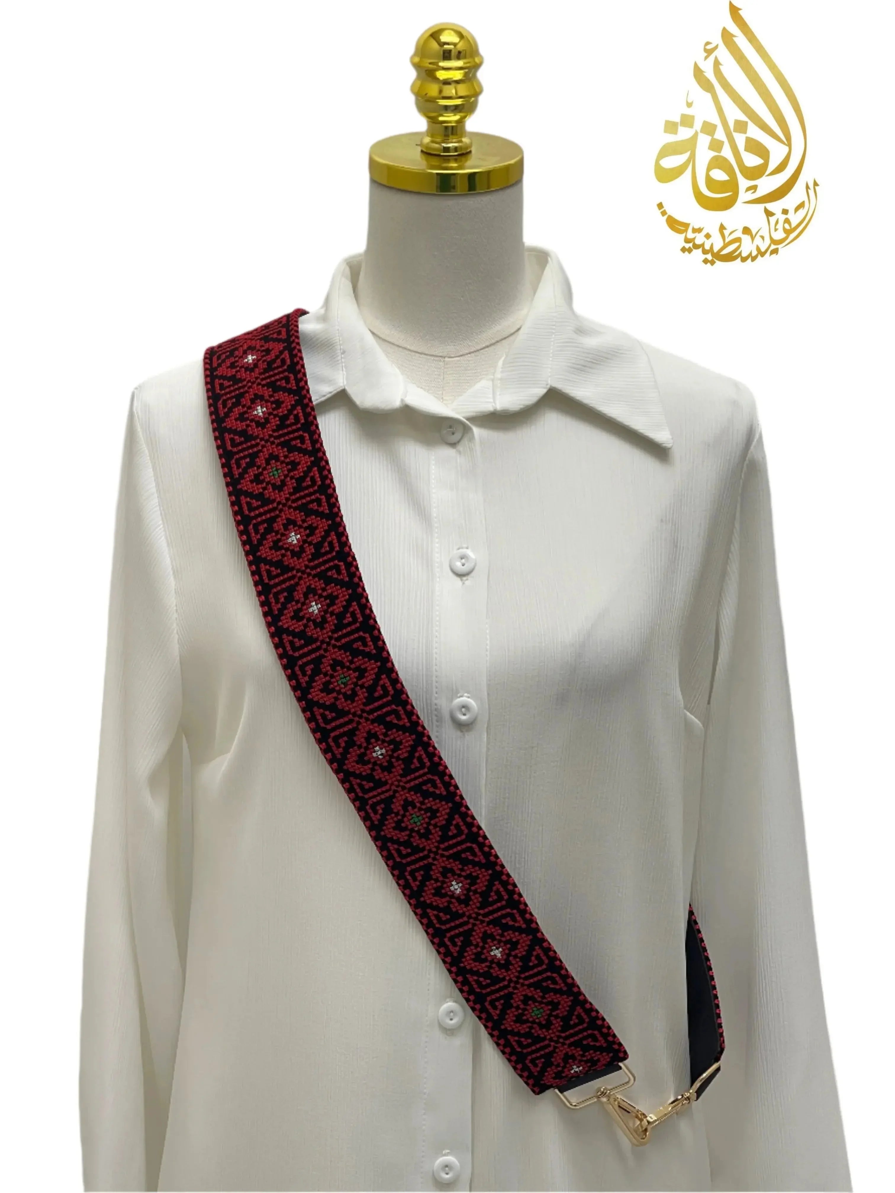 Embroidered Heritage Purse Strap in red and black geometric pattern displayed on white blouse