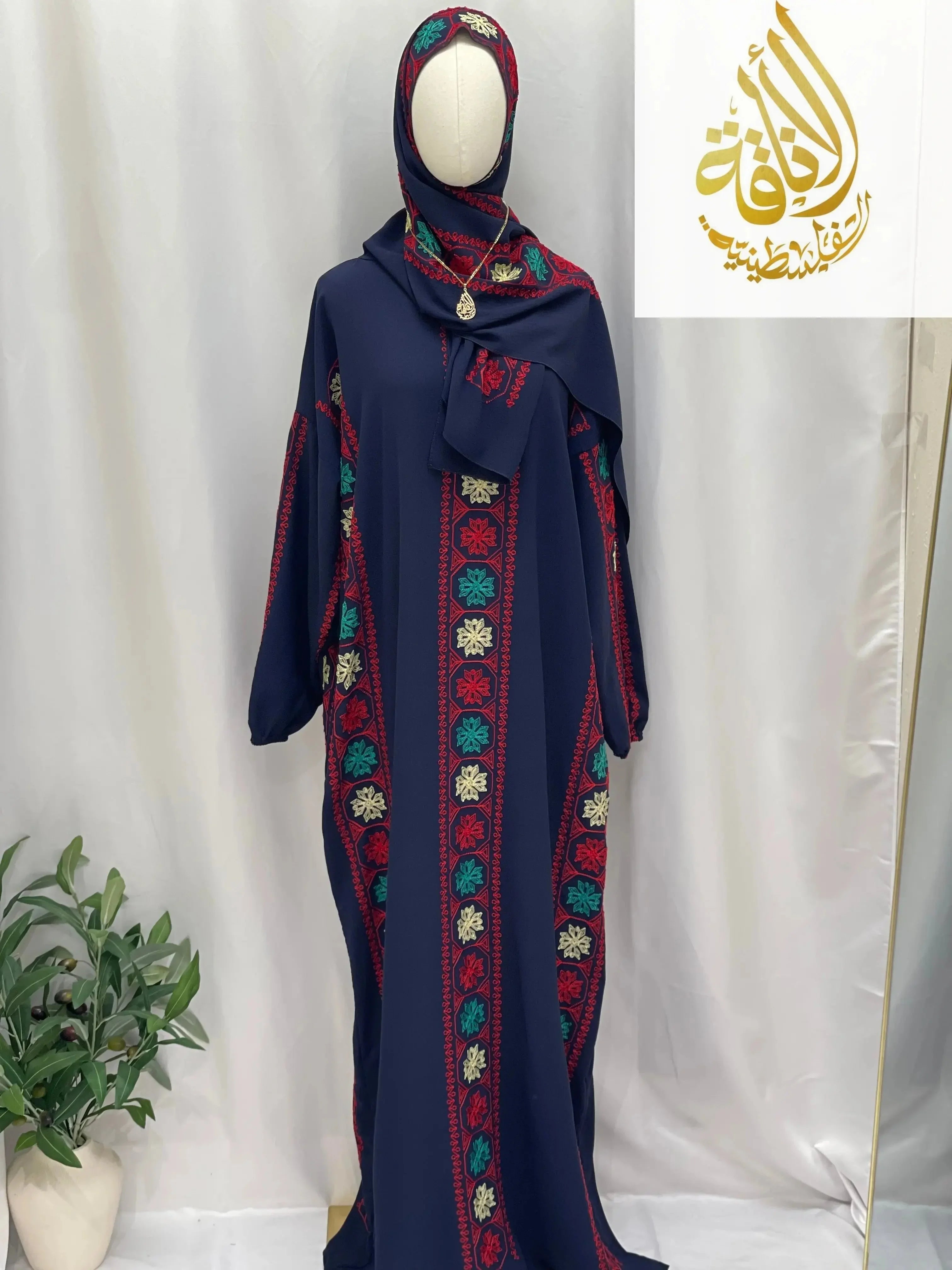 Palestinian Elegance navy embroidered prayer dress with floral patterns and matching headscarf on mannequin