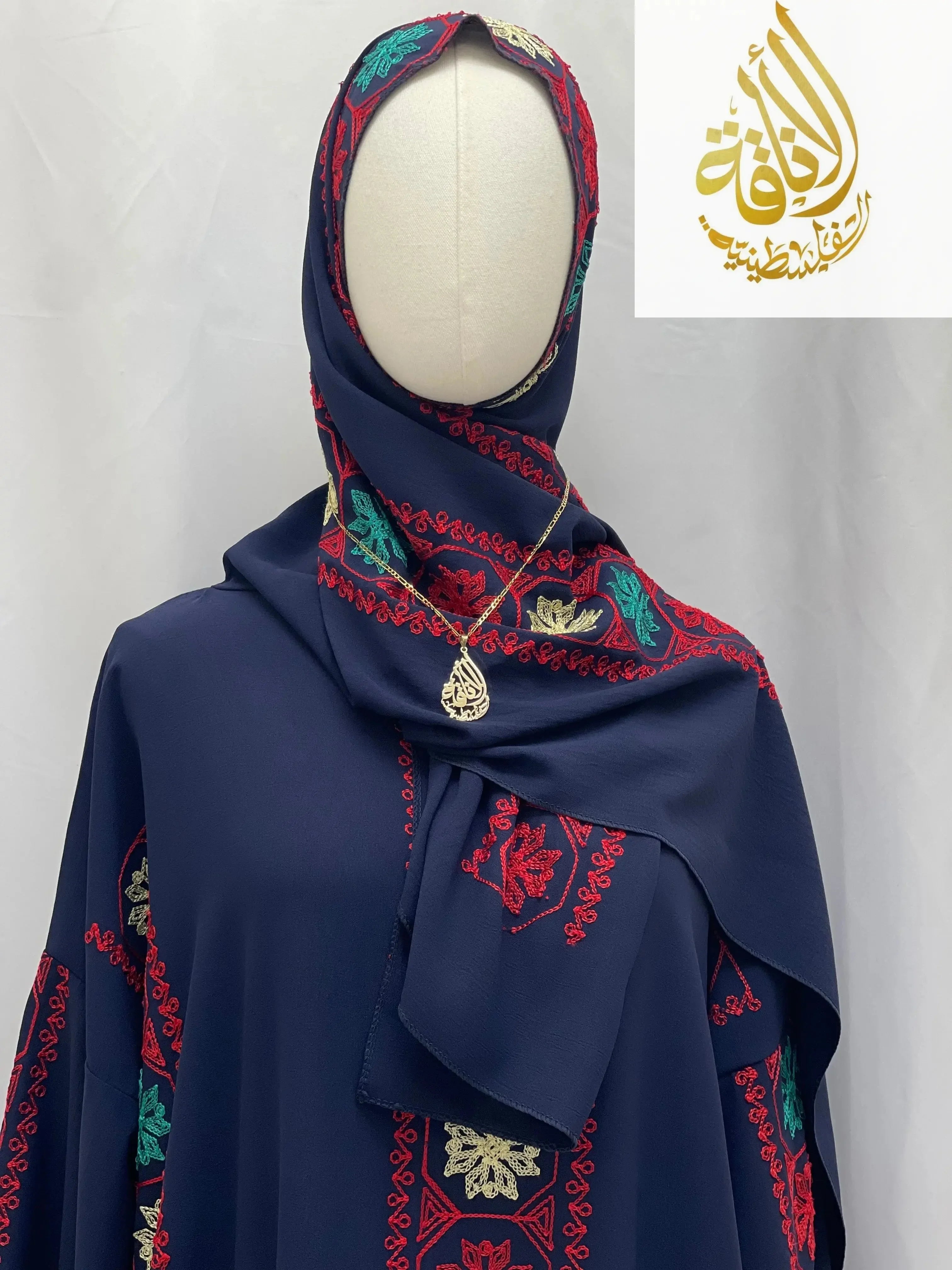 Palestinian Elegance embroidered prayer dress in navy blue with red and green embroidery on a mannequin