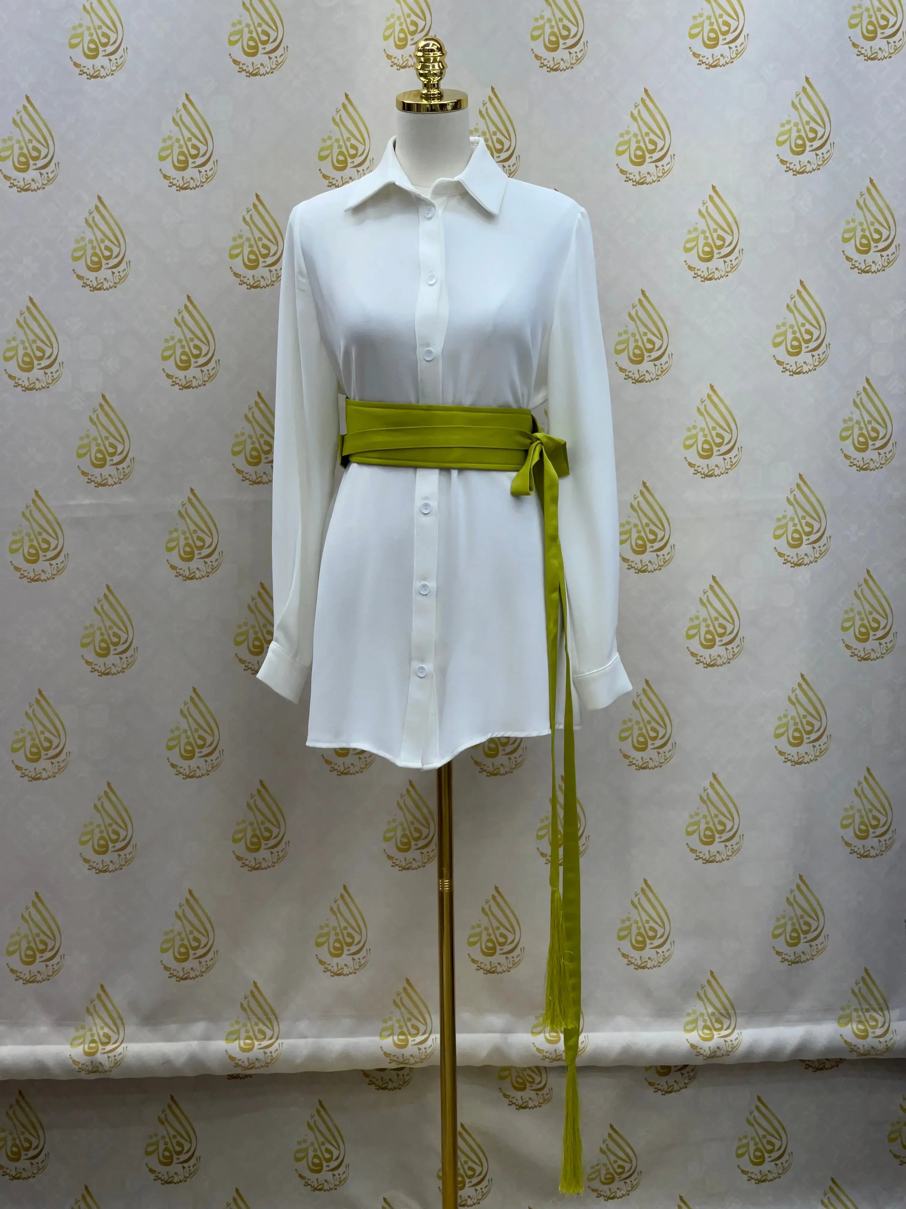 Luxury satin belt for dresses in olive green tied around white shirt dress on mannequin