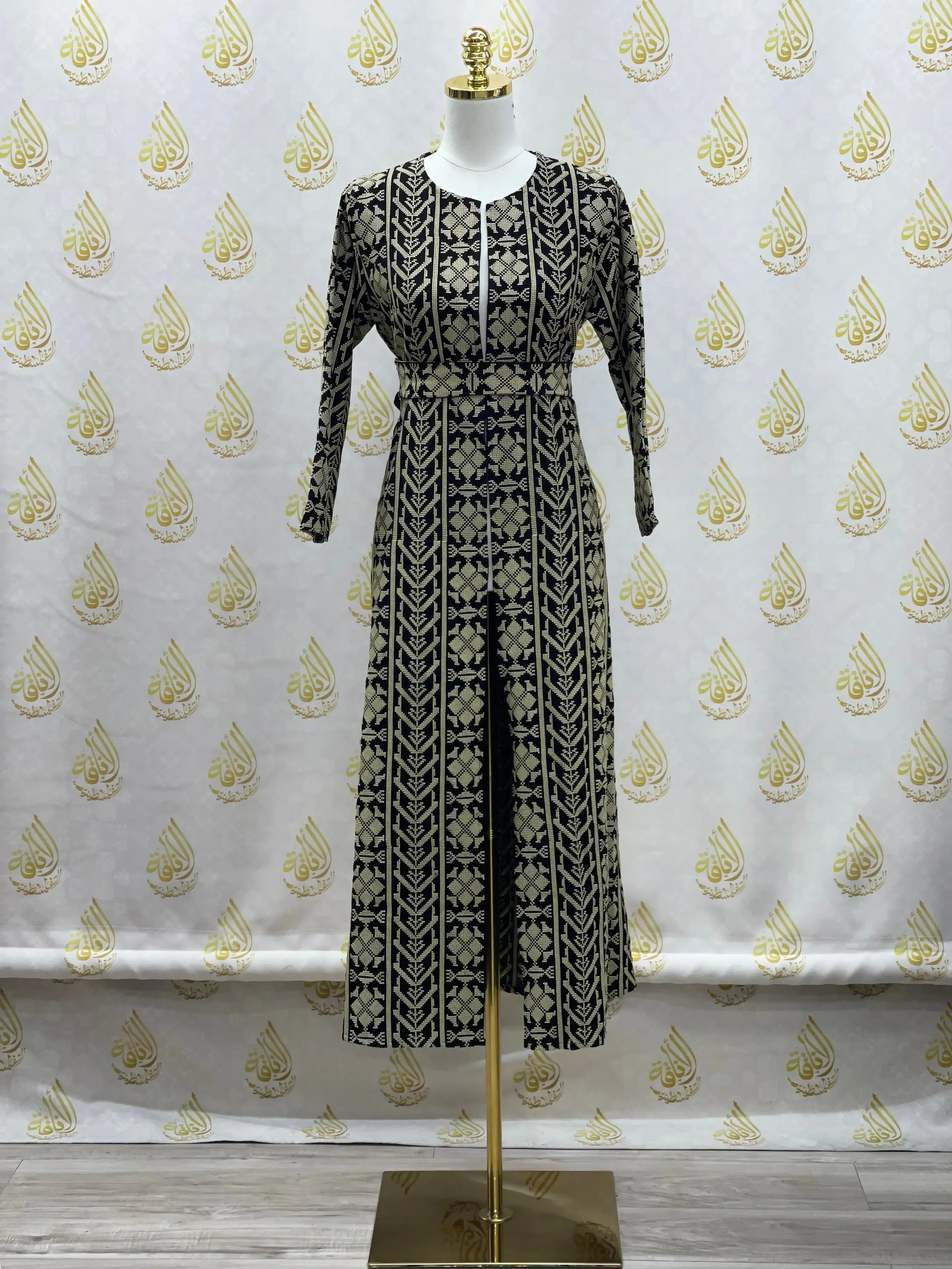 Palestinian Elegance embroidered cardigan for kids with traditional black and beige patterns on a dress form