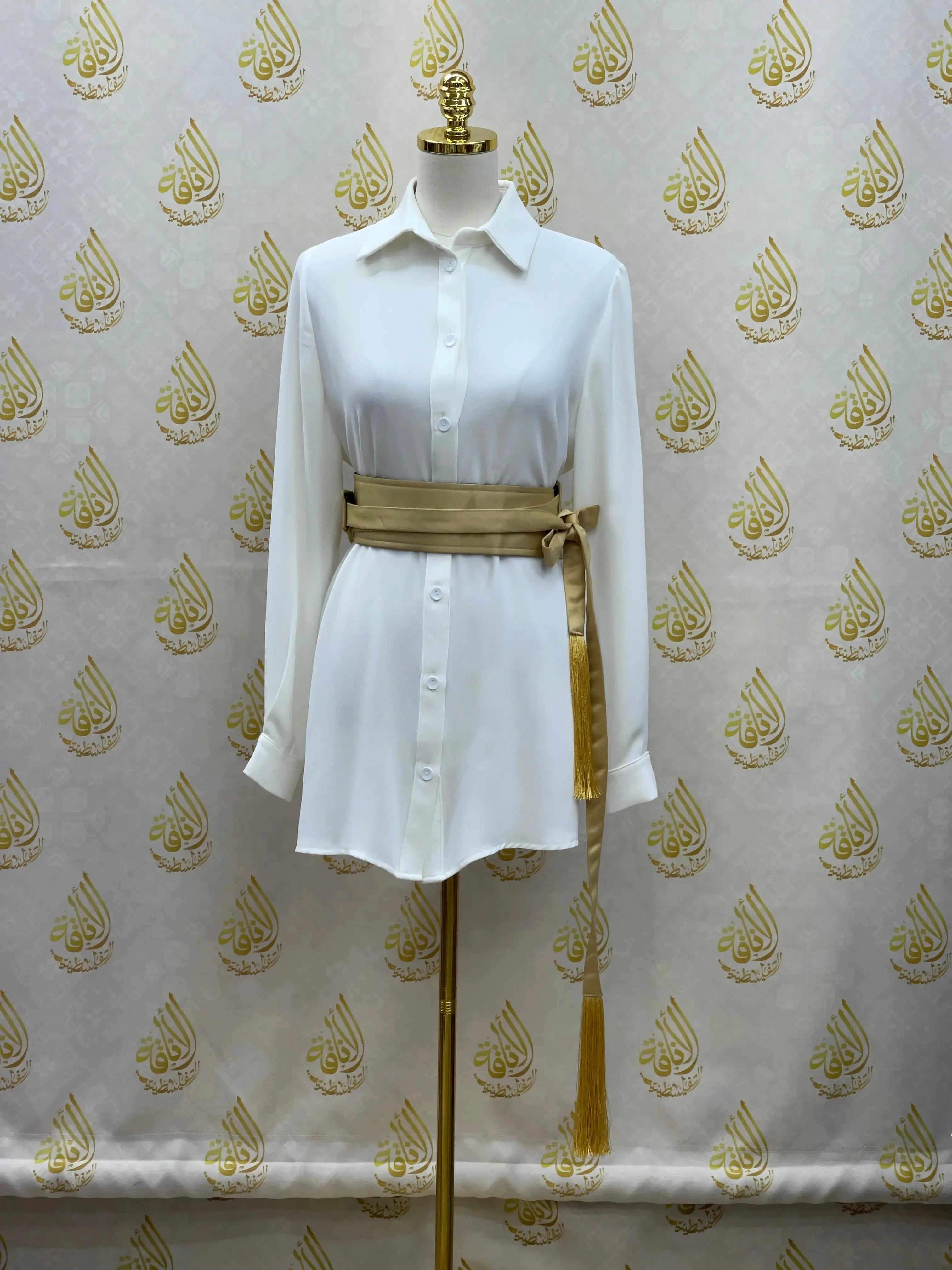 Luxury satin belt for dresses in gold tied around white button-up shirt on mannequin