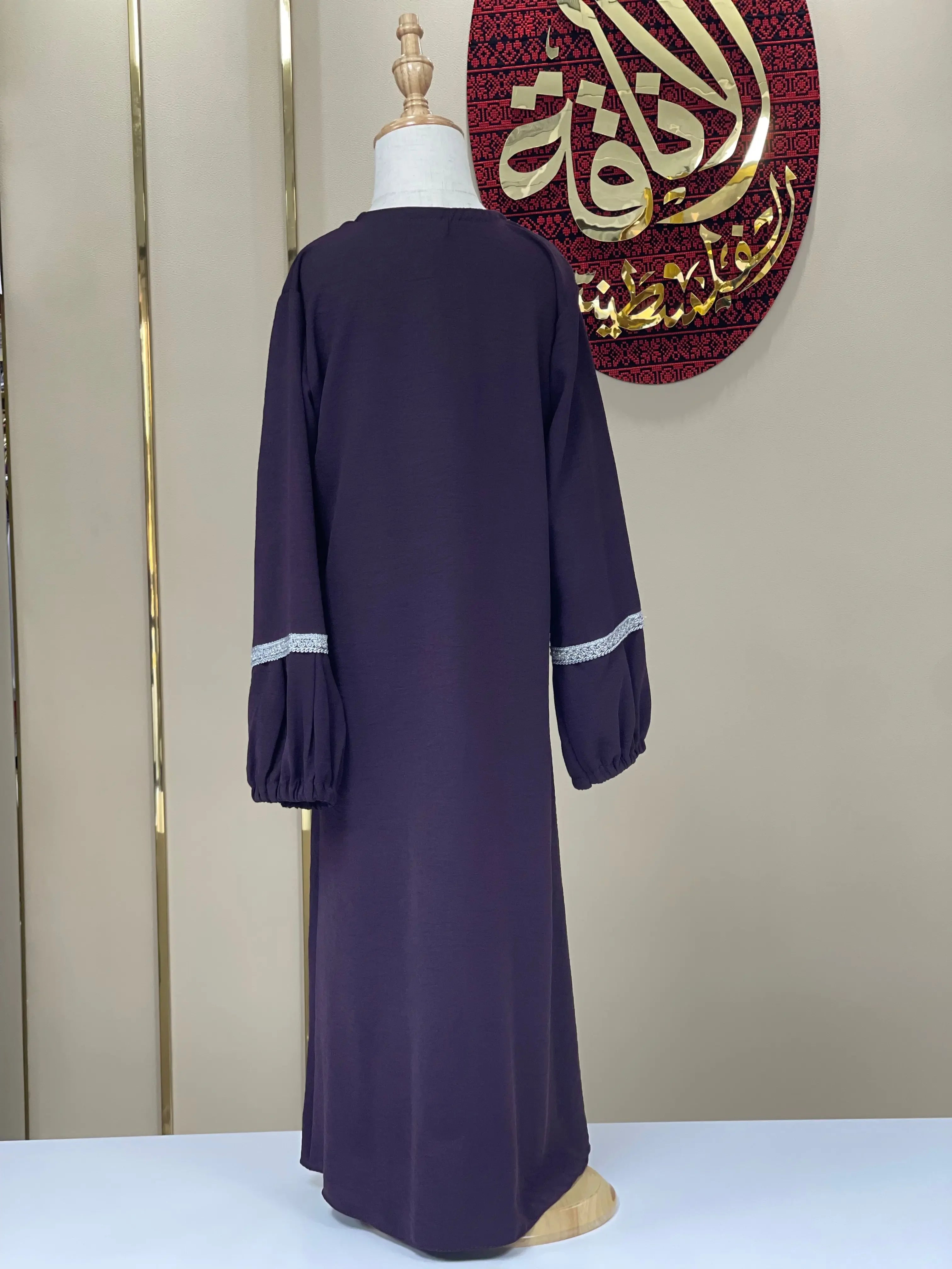 Back view of a girls embroidered abaya in dark purple with long sleeves and white embroidery detailing