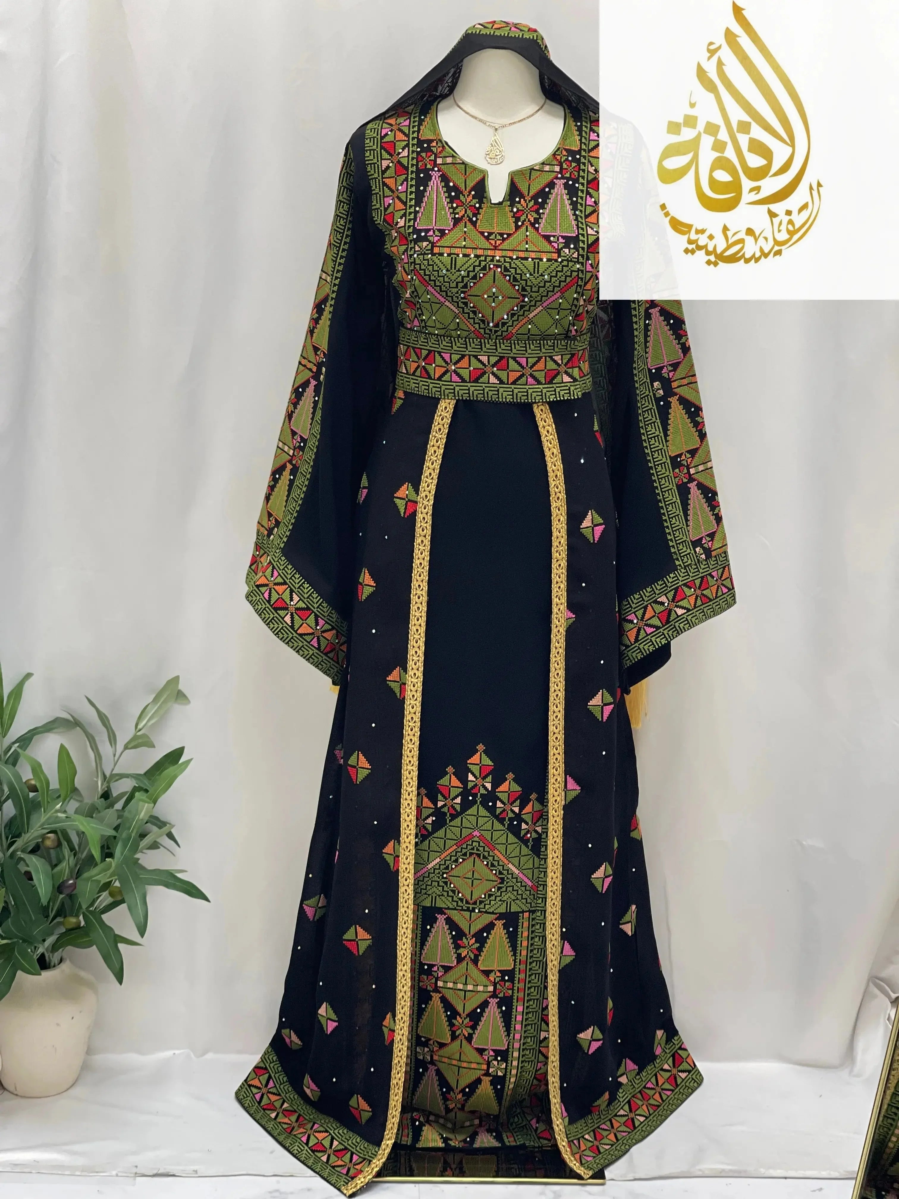 Embroidered Falahi thoub with overskirt by Palestinian Elegance featuring intricate colorful geometric patterns on black fabric
