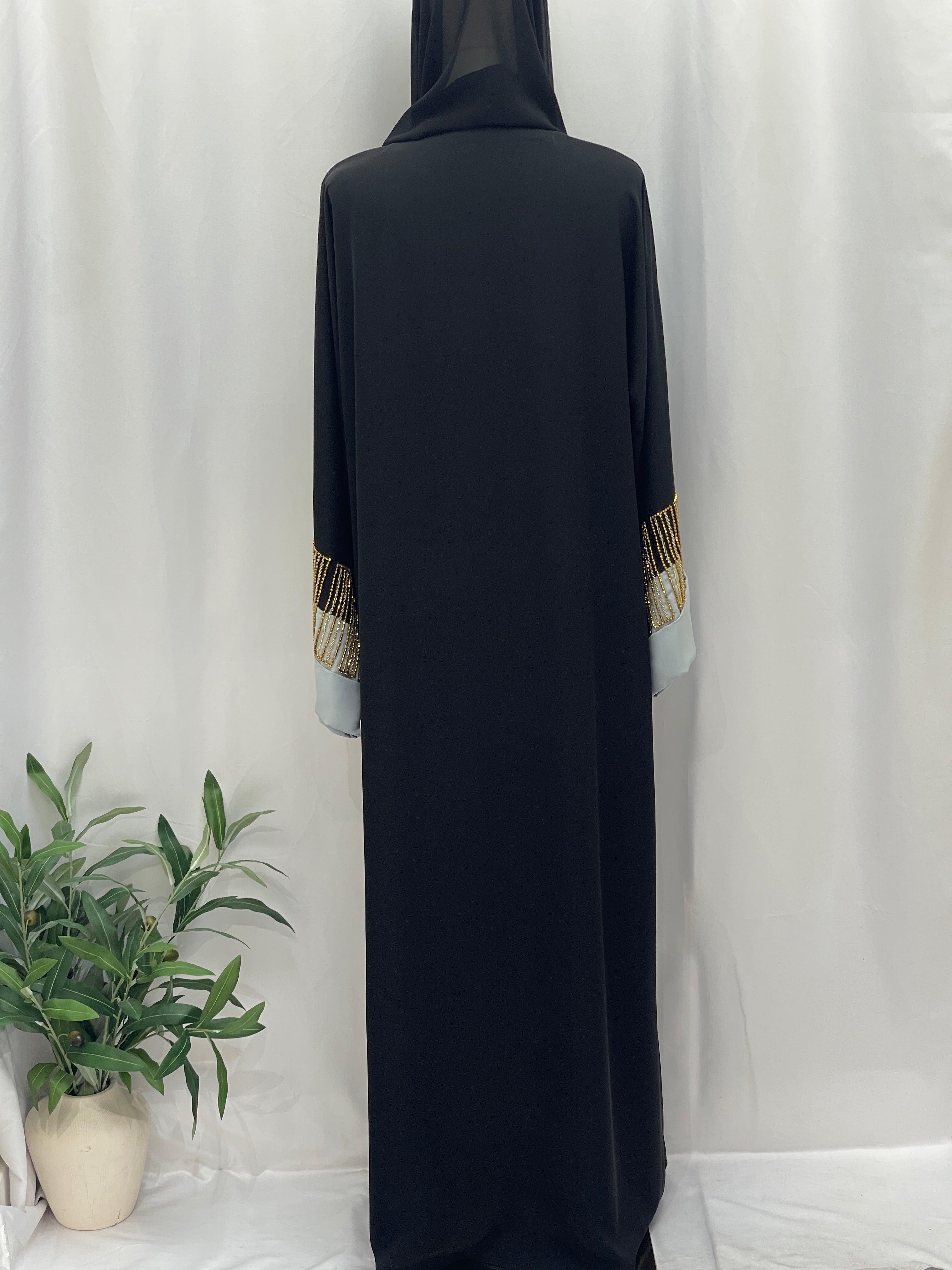 Palestinian Elegance black abaya back view with gold beaded cuff accents and white inner sleeves Fancy Beads Dubai Abaya