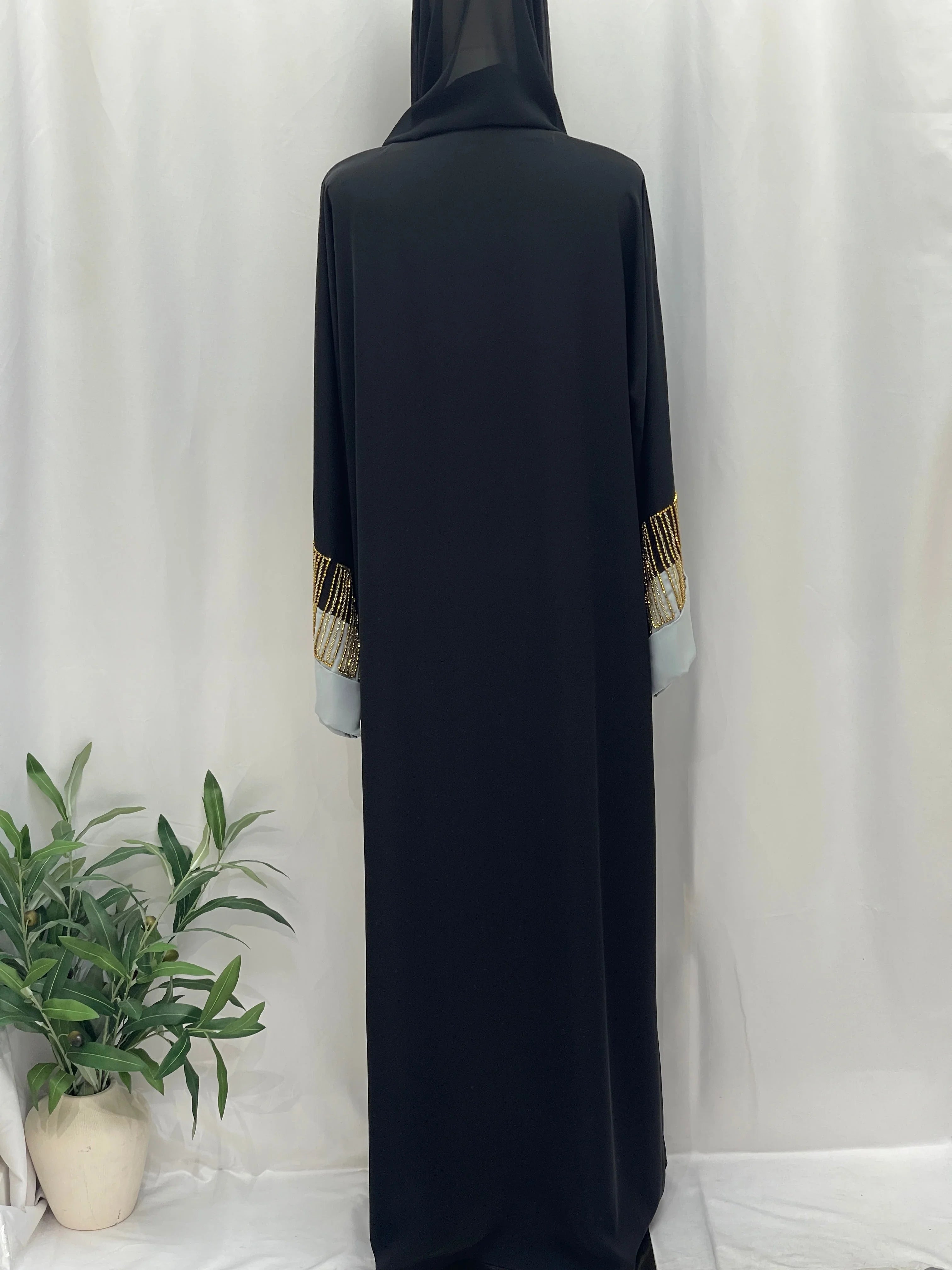 Palestinian Elegance black abaya back view with gold beaded cuff accents and white inner sleeves Fancy Beads Dubai Abaya