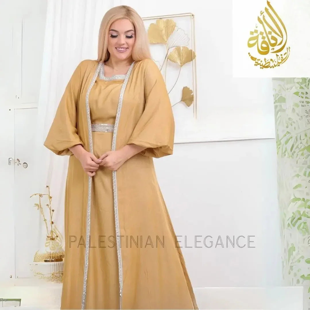 Elegant gold fancy dress abaya online from Palestinian Elegance with silver trim and flowing sleeves