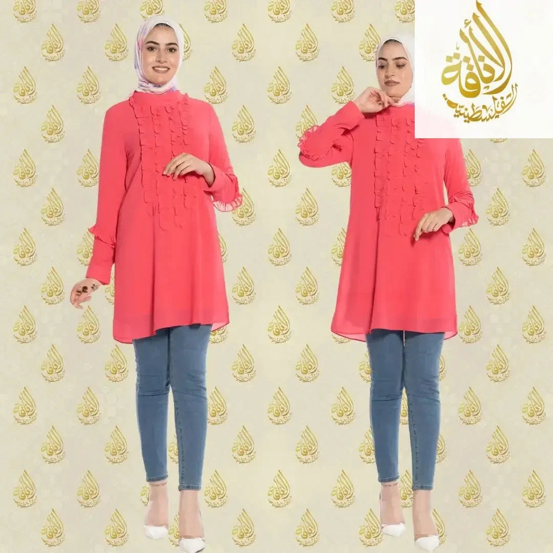 Luxury women's embroidered shirt in coral pink by Palestinian Elegance worn with blue jeans and white heels